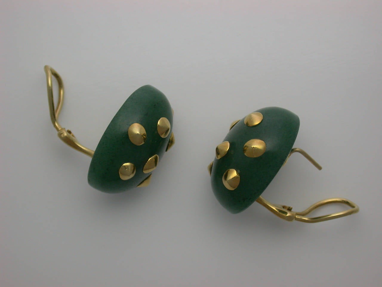 The soft, domed ovals carved from translucent green aventurine quartz, a hard stone with fine graining like that of nephrite jade, decorated playfully with randomly-placed polished yellow gold thorn accents, omega clip backs and posts, unsigned, an