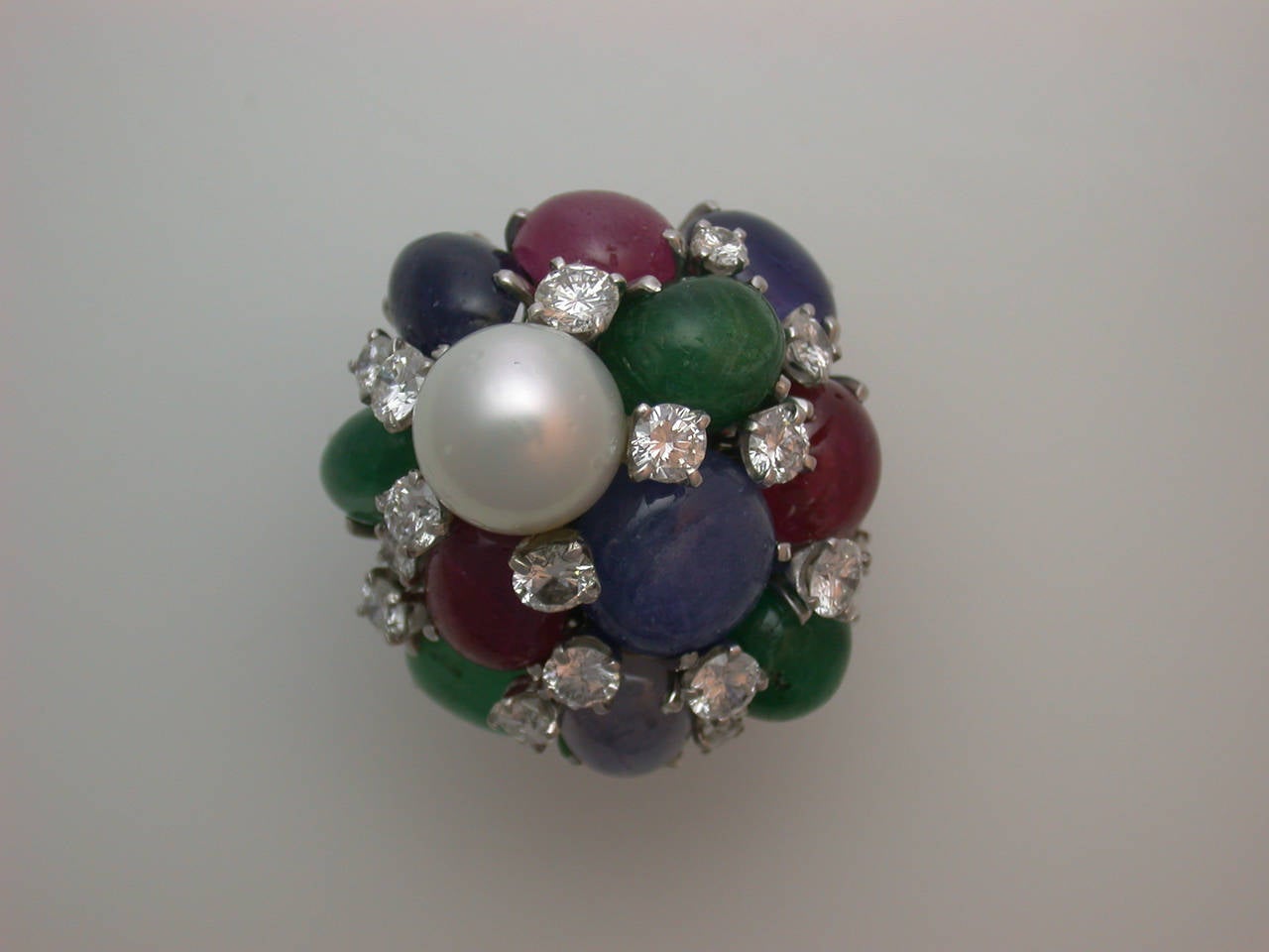 The very large, domed ring designed like a giant bubble of cabochon rubies, sapphires and emeralds (3 rubies weighing approximately 8 carats total, 4 emeralds weighing approximately 9 carats total, 4 sapphires weighing approximately 12 carats total)