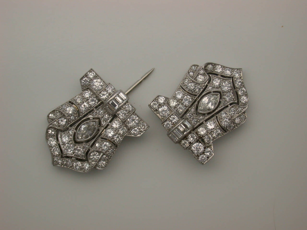 The elegant pair of dress clips (each measuring 1 inch high by 7/8 inch wide held vertically) set with marquise, baguette and circular-cut white diamonds (approximately 4 carats total weight), mounted in platinum (26.2 g) designed in classic late