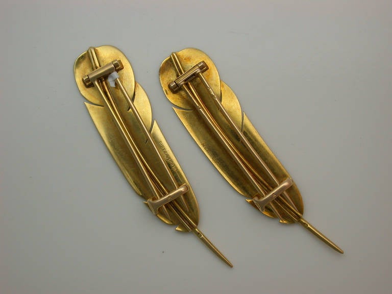 Two finely chased yellow gold feathers, French, by Parisian luxury brand Hermes, typical of 1950s post-War glamour, to be worn with a twin set or on a lapel, with hinged, double-pin clip backs and safety catches, one signed Hermes and one signed