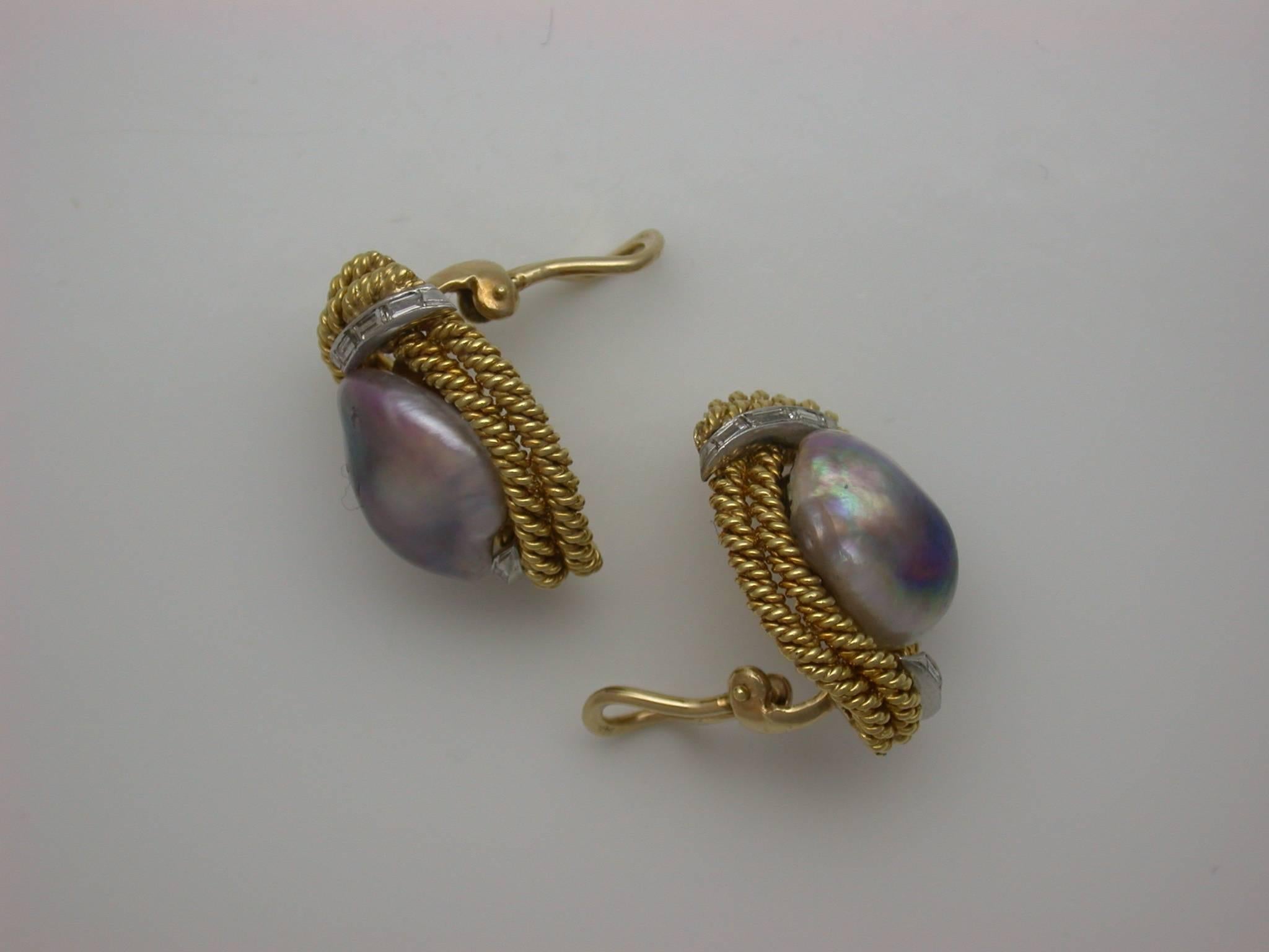 The tailored earclips designed as vertical oval frames, built from double rows of twisted yellow gold rope, centering large silver baroque freshwater pearls with pinkish-purple overtones, enhanced at top and bottom by baguette-cut diamond arcs