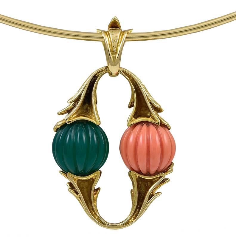 Two melon-carved beads measuring approximately 10mm, one salmon orange one chrysoprase, held between brushed yellow gold foliate arcs to create an oval pendant, suspended from a flexible trifid bail, with French maker's mark, French assay mark for