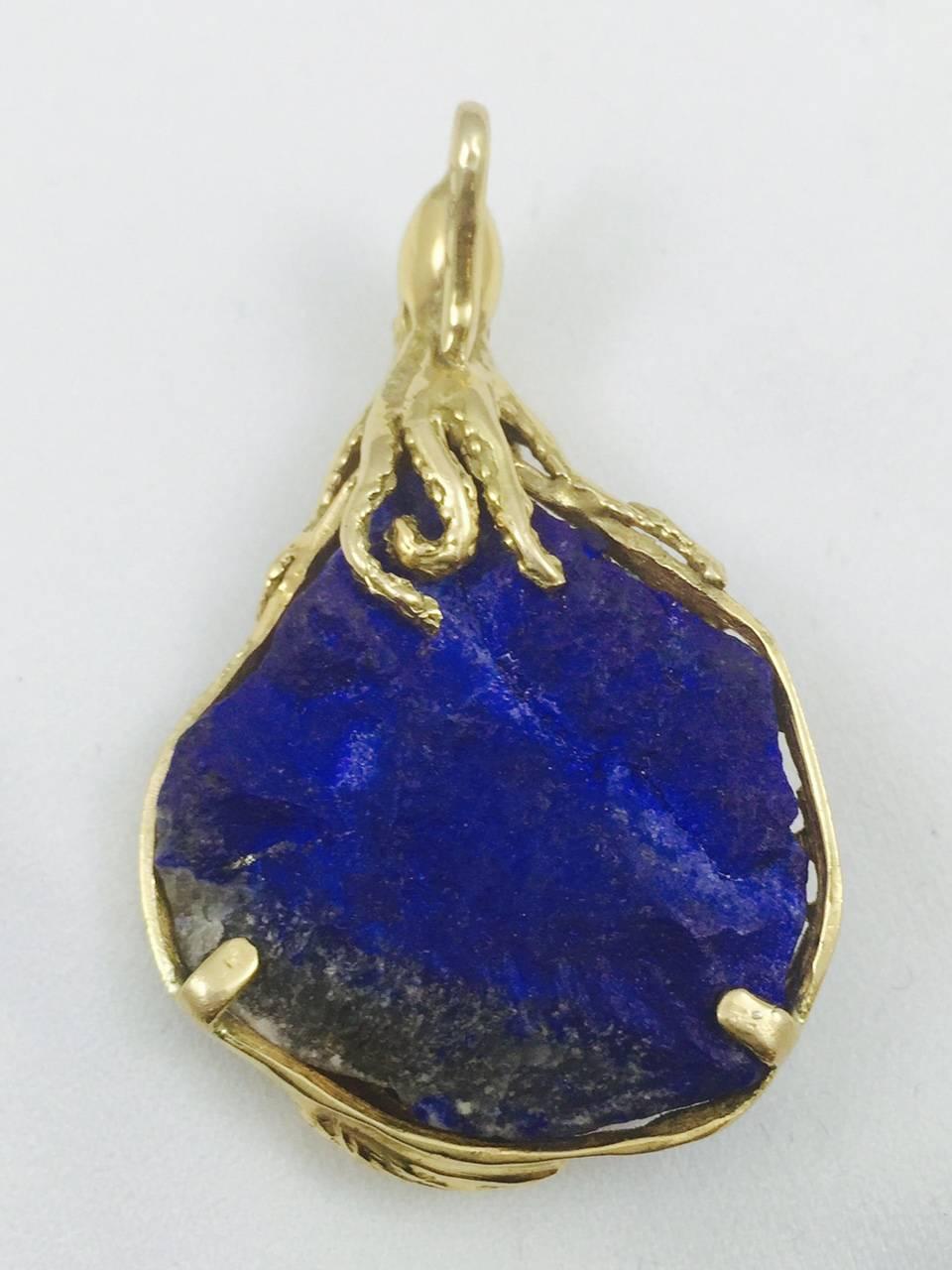 Magnificently crafted in 18 karat yellow gold, this large organic piece of Lapis Lazuli has been artfully adorned.  Three nautical enhancements include a shell, a starfish and a crab all containing a bezel set brilliant cut diamond.    Three more