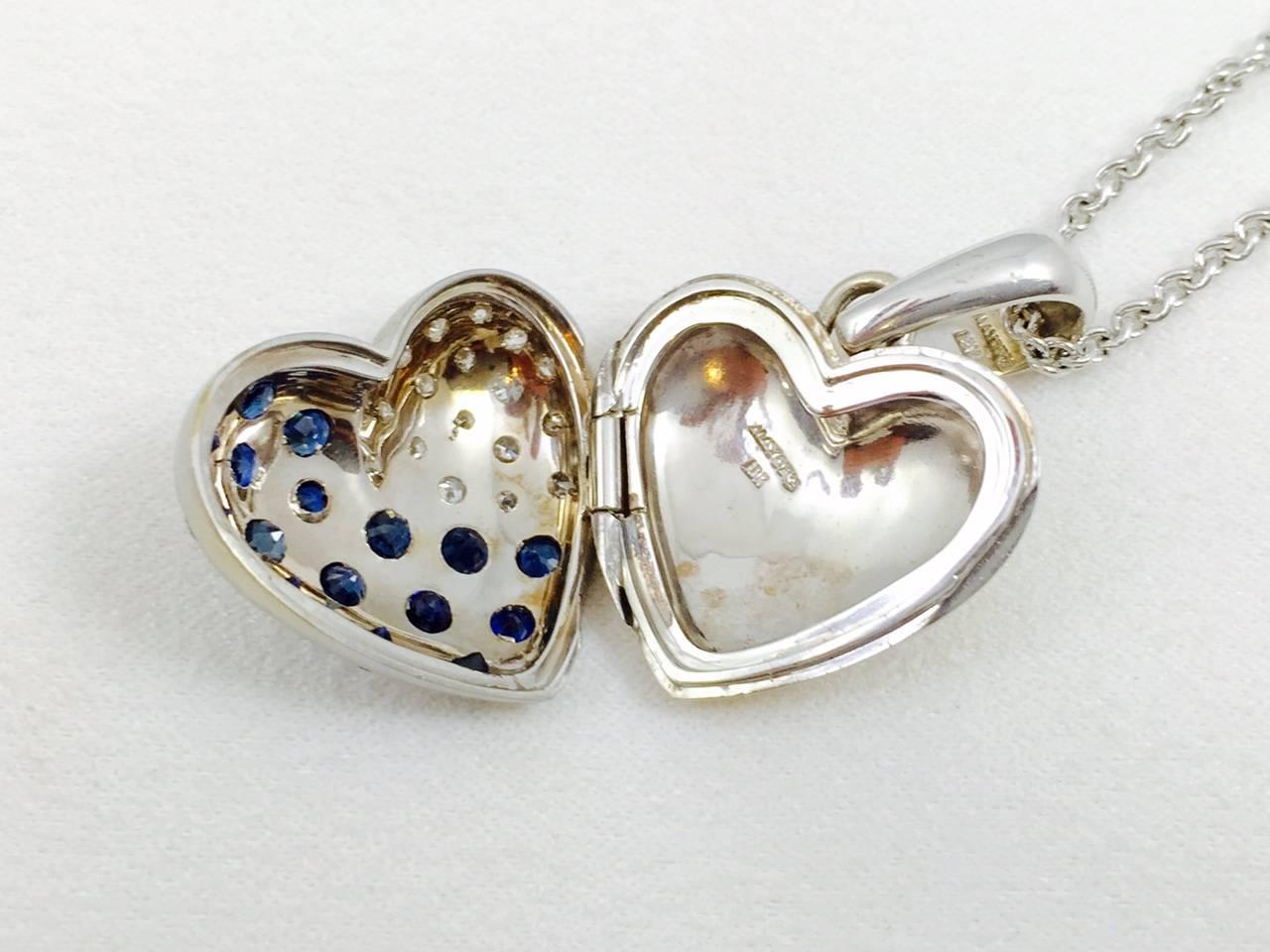 Magnificent heart shape locket in 18 karat white gold matte finish front.  Burnish set white diamonds and blue sapphires make this working locket highly unusual and visually stunning!  Sapphires have an approximate total weight of 2.00 carats. 