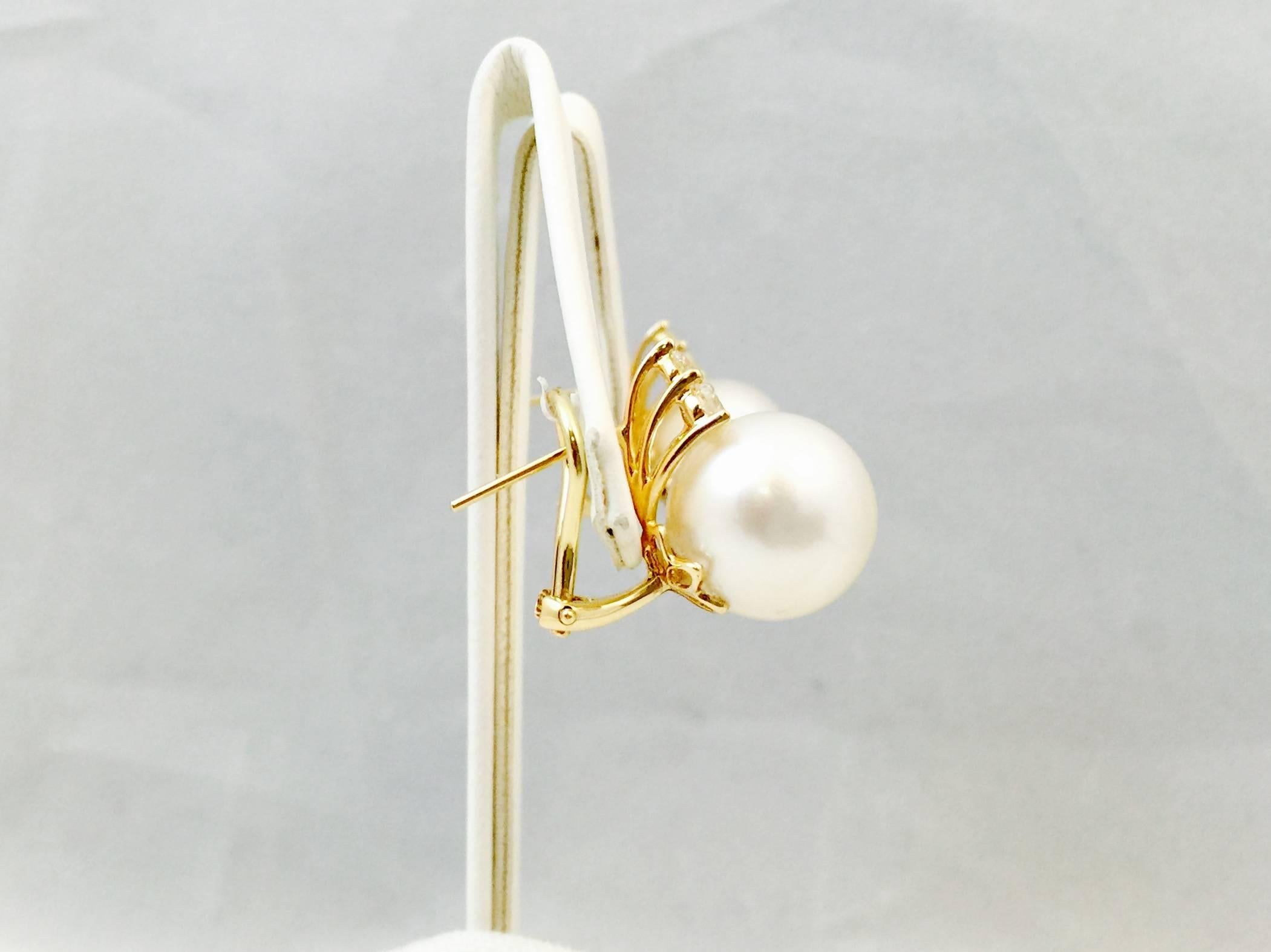 What could be more classic than a pair of pearl and diamond earrings?  These beauties, however, go to loftier heights!  18 karat yellow gold the base for perfectly matched 12MM white cultured South Sea Pearls with high lustre, topped by three