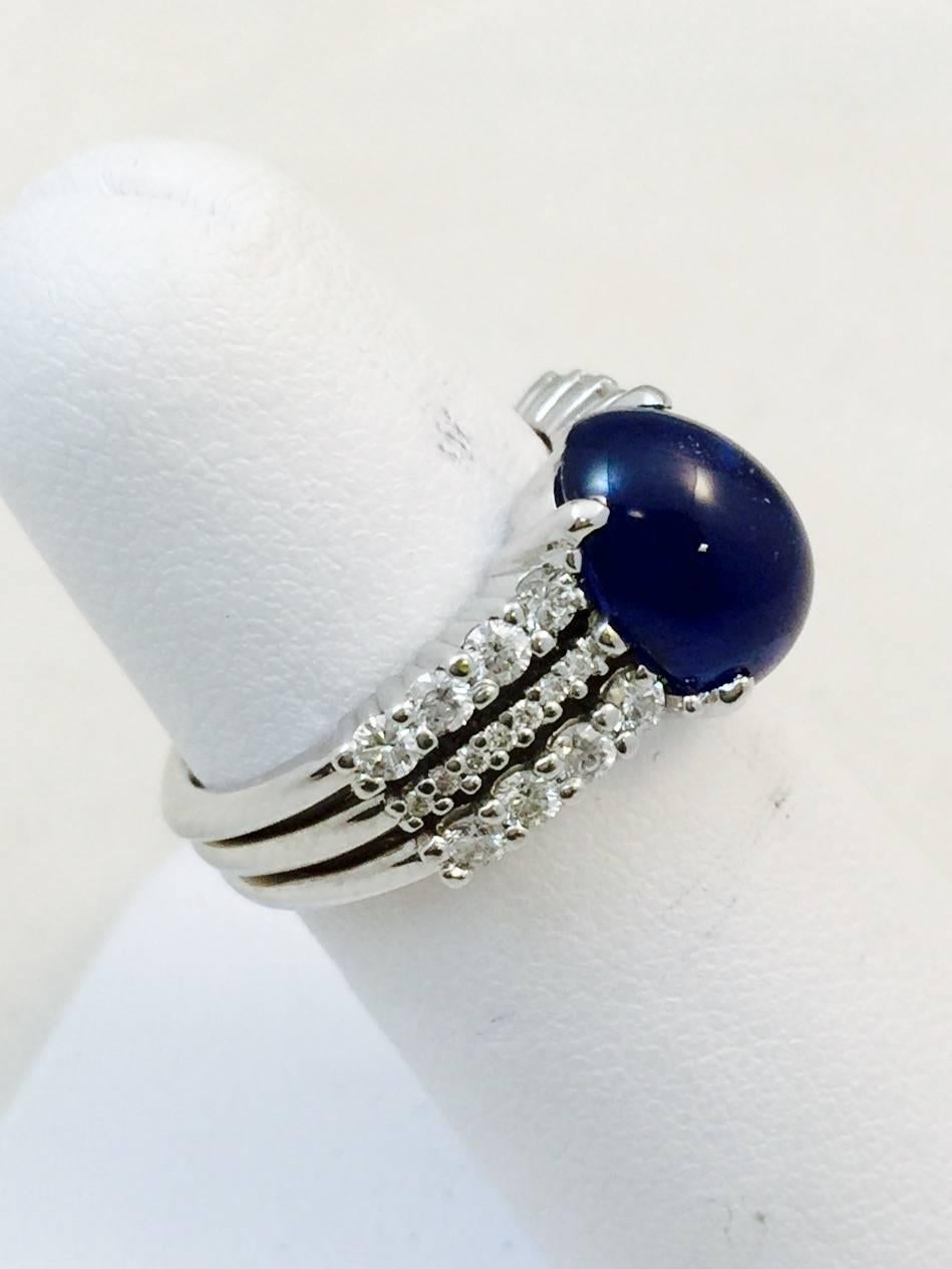 The perfection of pairing blue sapphire and diamonds creates an iconic look!
Fabricated in 18 karat white gold, featuring an oval prong set Ceylon cabochon  blue sapphire weighing 4.99 carats.  Brilliant cut white diamonds are prong set in three