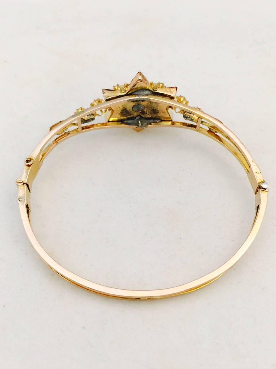 Fabricated circa 1870's, this 14 karat yellow gold antique bangle bracelet features a star design top containing Rose cut natural blue tinted diamonds weighing approximately 1.25 carats total. Delicate yet sturdy construction.  Bracelet opens wide