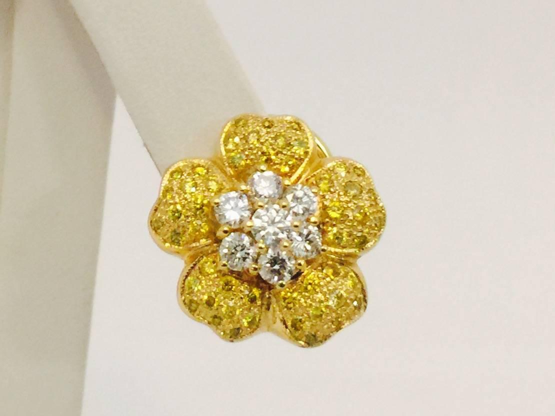 Flowers to last for generations!  Stunning 18K yellow gold pierced, Omega back earrings depict the ever stylish flower shape.  Perfectly matched natural Yellow diamonds encrust each petal.  Perfectly matched White diamonds form center clusters. 