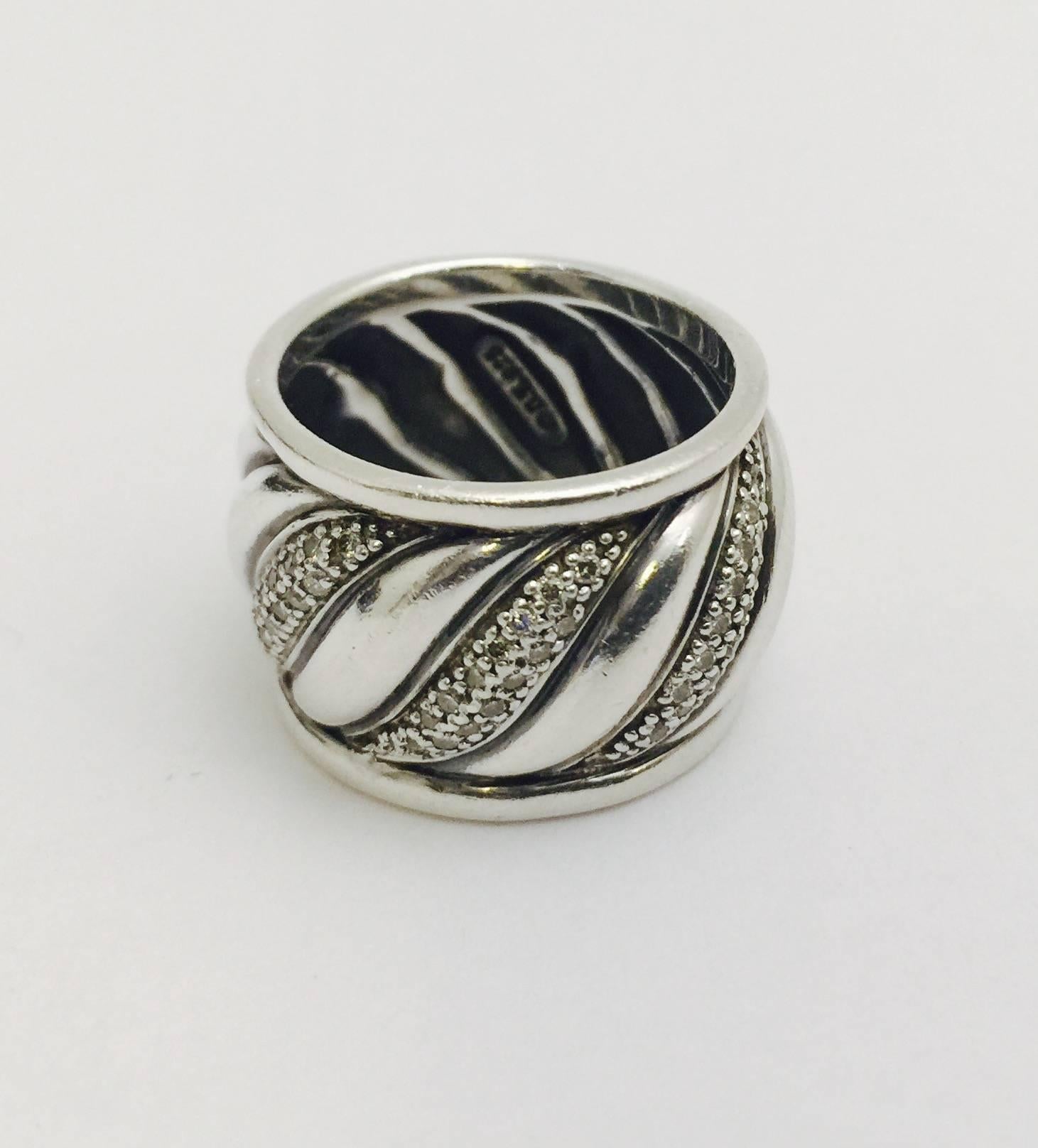David Yurman set the Fine Jewelry world on fire by being the first designer to incorporate diamonds set in Sterling Silver.  Great idea!  This classic band style ring with graceful curves exemplifies elegance in simplicity.  Three sections contain