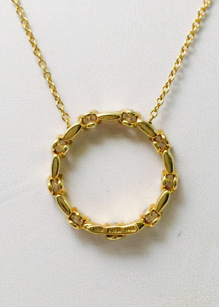 Eternity.  The symbol of a circle.  This 18 karat yellow gold 18" necklace by Roberto Coin features a circle affixed to the chain.  Nine white, fully faceted brilliant cut diamonds are sprinkled around the circle.  Approximate total weight 0.50