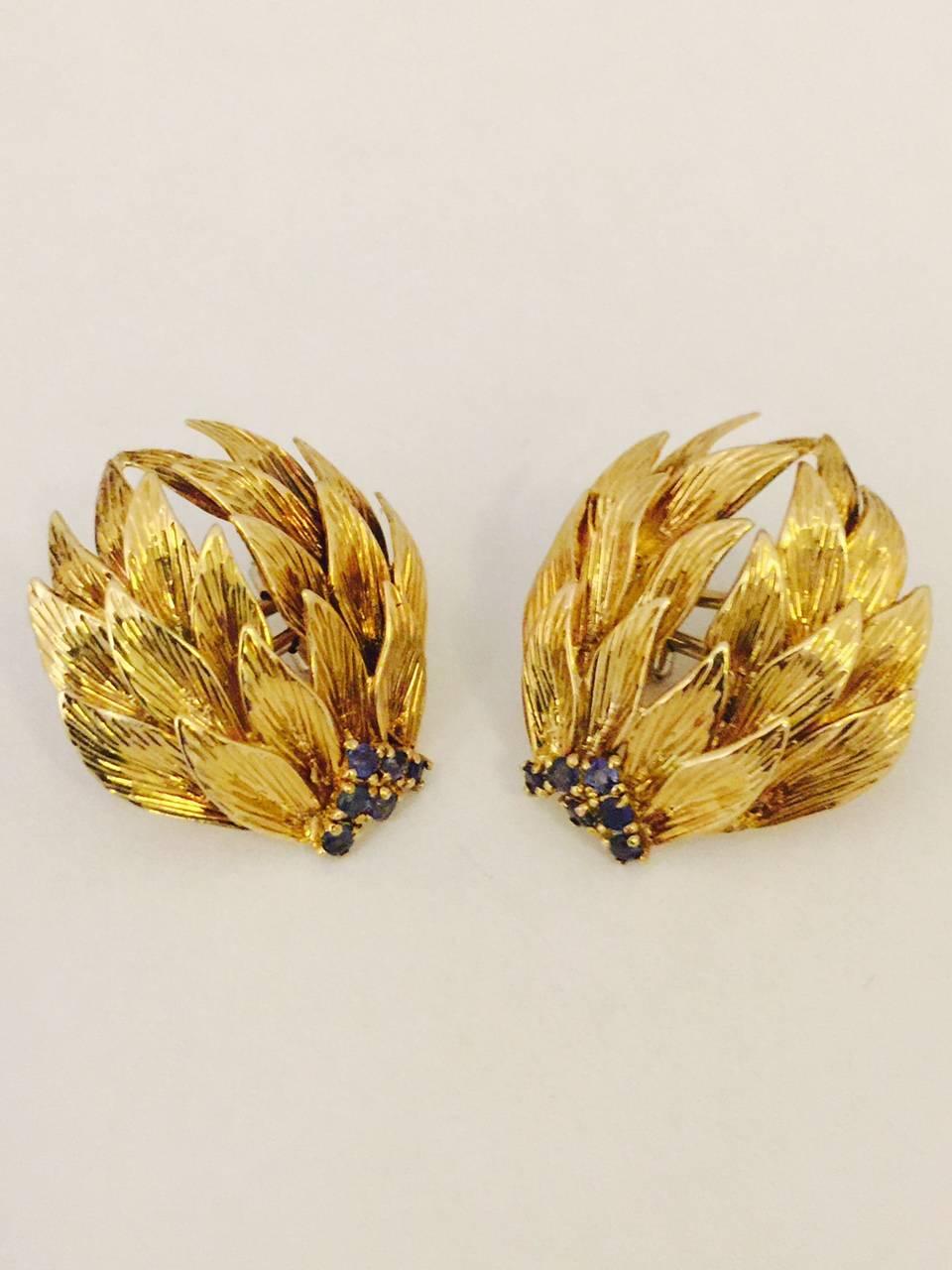 A most unusual earring!  Specifically made for left and right wear, so that the sapphires frame your face.  So flattering!  Each 18 karat yellow gold leaf is heavily engraved and life like!  Twelve beautifully matched, faceted round blue sapphires