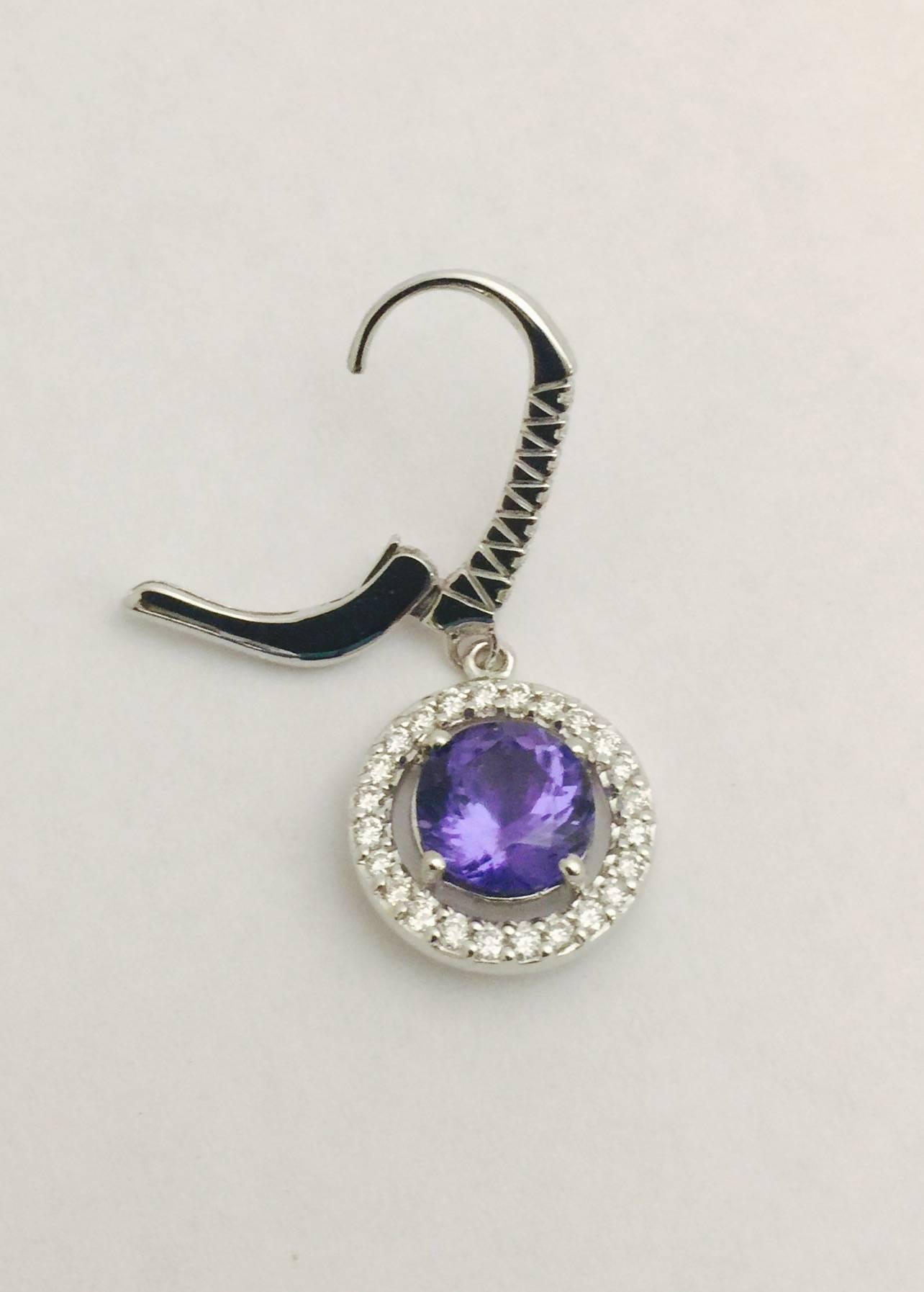 The popularity of tanzanite soars as supply diminishes.  These beautifully crafted 18 karat white gold earrings feature perfectly matched, faceted, round tanzanites with a total weight of 2.87 carats.  Secure lever backs for pierced ears feature