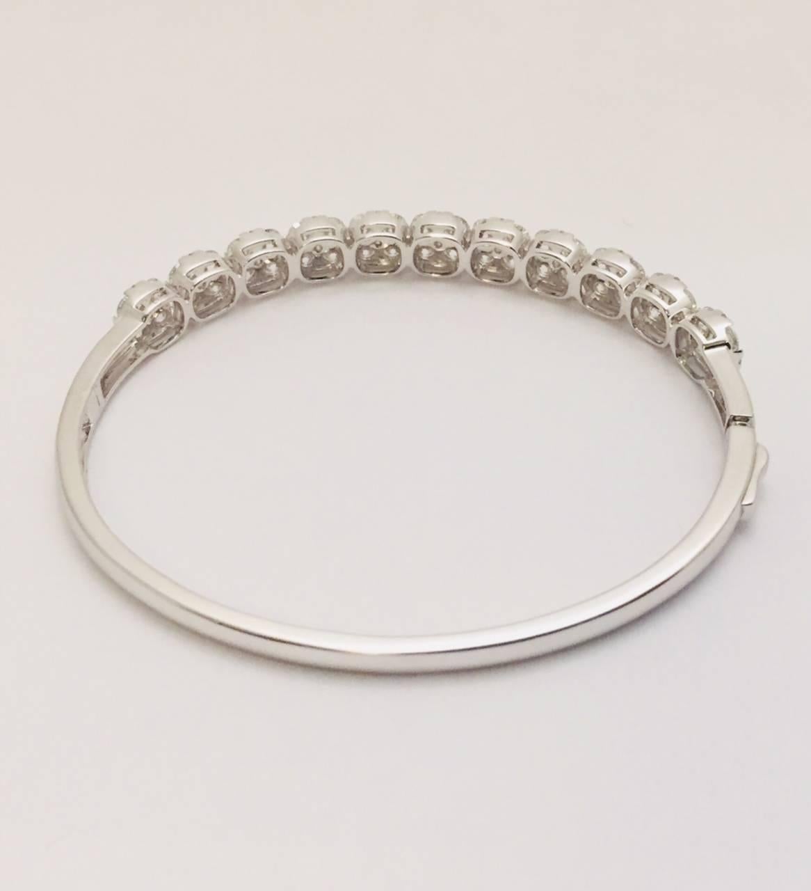 Quintessential 18K White Gold and Diamond Bangle Bracelet is elegance defined.  Features 44 round cut diamonds weighing 4.49cts and an additional 55 round cut diamonds weighing .50cts - almost a total of 5 carats!  Clamp closure.  Promises to become