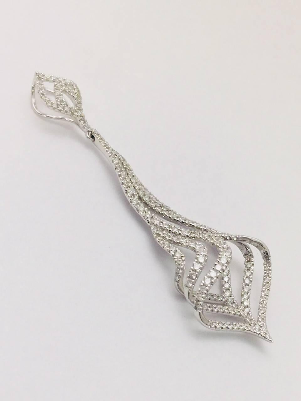 Masterfully designed in 18 karat white gold, this pendant is spectacular!  Open work top anchors a drop of curved and swirled rows containing 173 round diamond with a total weight of 0.97 carats.  Width of 0.75