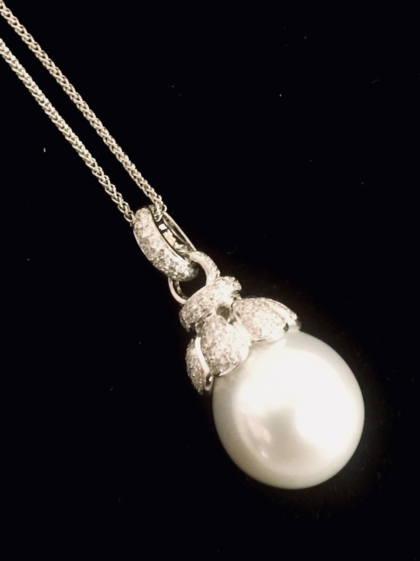 Elegance in Simplicity is the greatest description to this splendid South Sea Pearl and Diamond necklace.  18 karat white gold open link chain finished with lobster claw clasp proudly holds a diamond capped 13.5mm white South Sea pearl.  The curved,