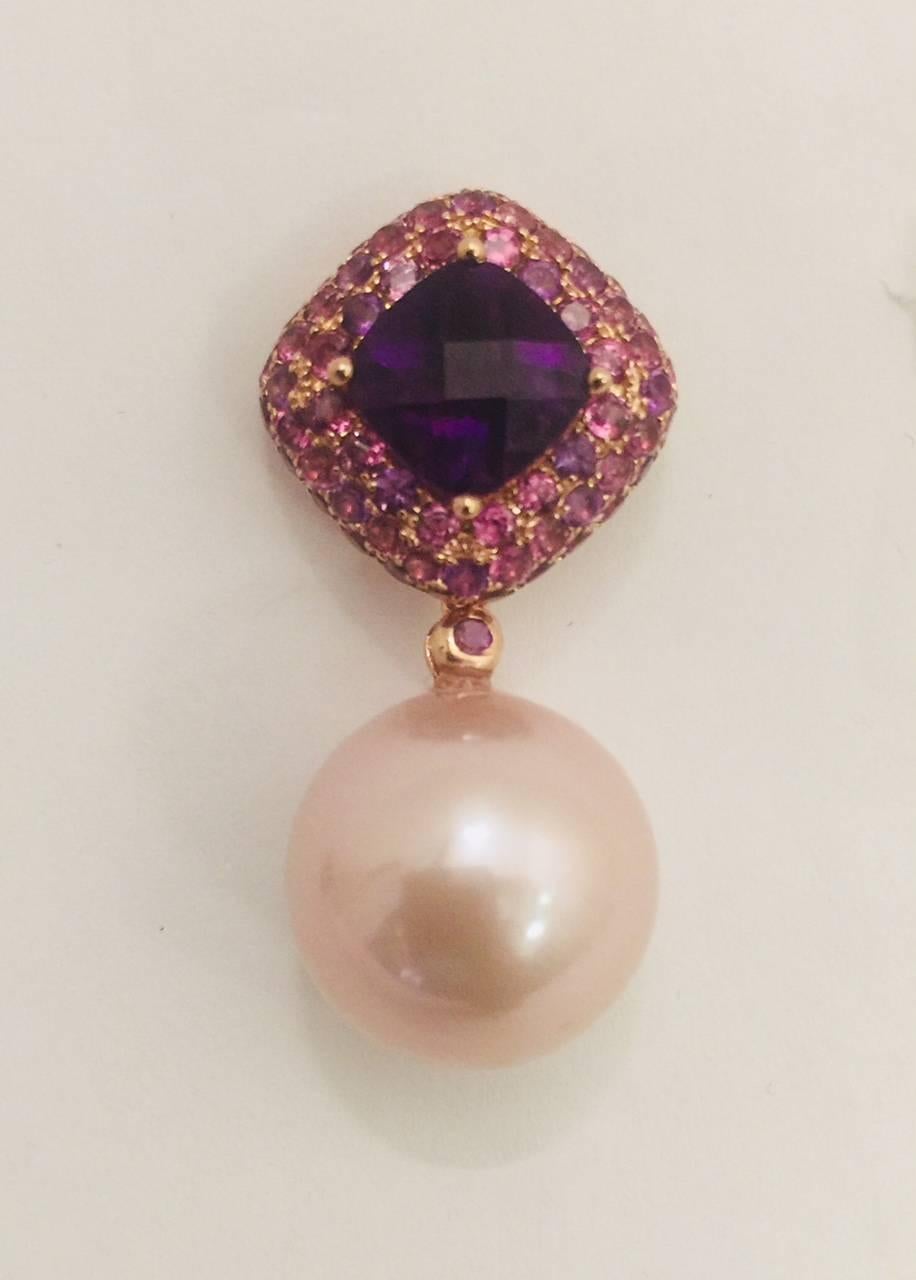 These earrings have a stunning and unique color combination!  Crafted in 18 karat rose gold they feature a top section with prong set rhodolite garnets and amethysts.  Centered you find a prong set checkerboard faceted, cushion shape amethyst. 