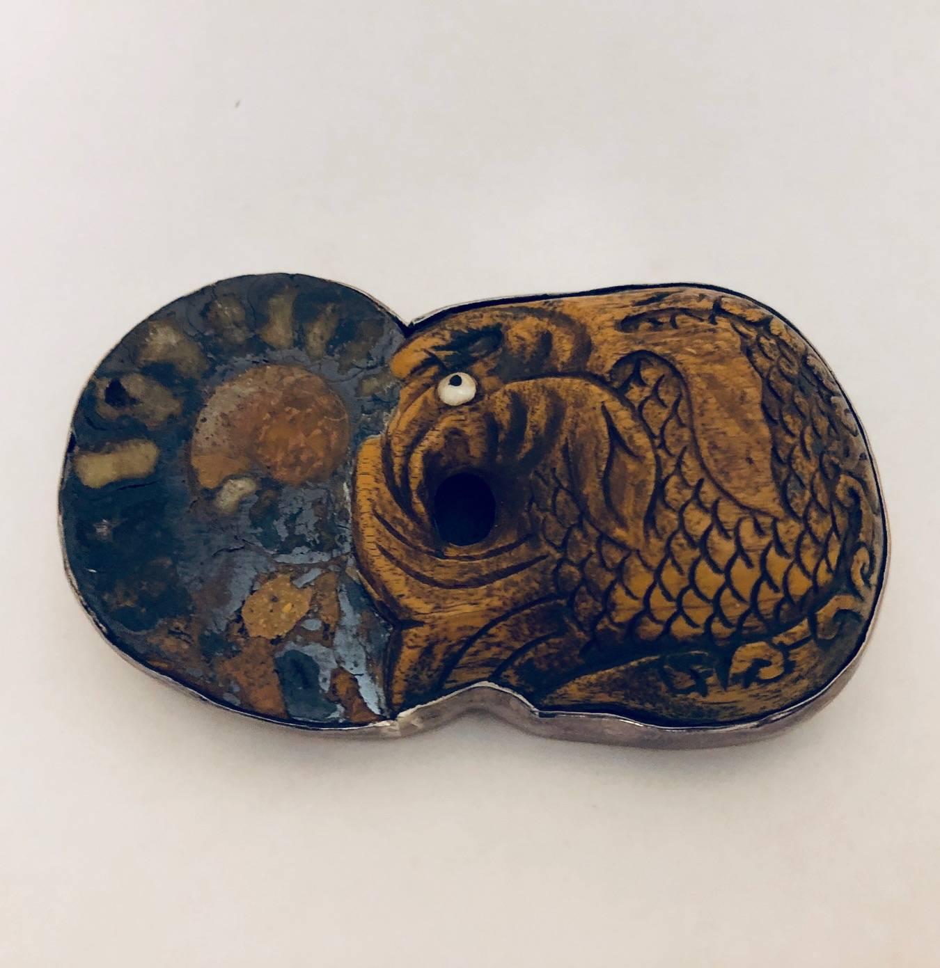 Amy Kahn Russell is famous for unique, one of a kind brooches that double as pendants!  Multitasking jewelry is always a great find!  This unusual piece features an intricately hand carved wood fish attached to a mesmerizing slice of fossilized