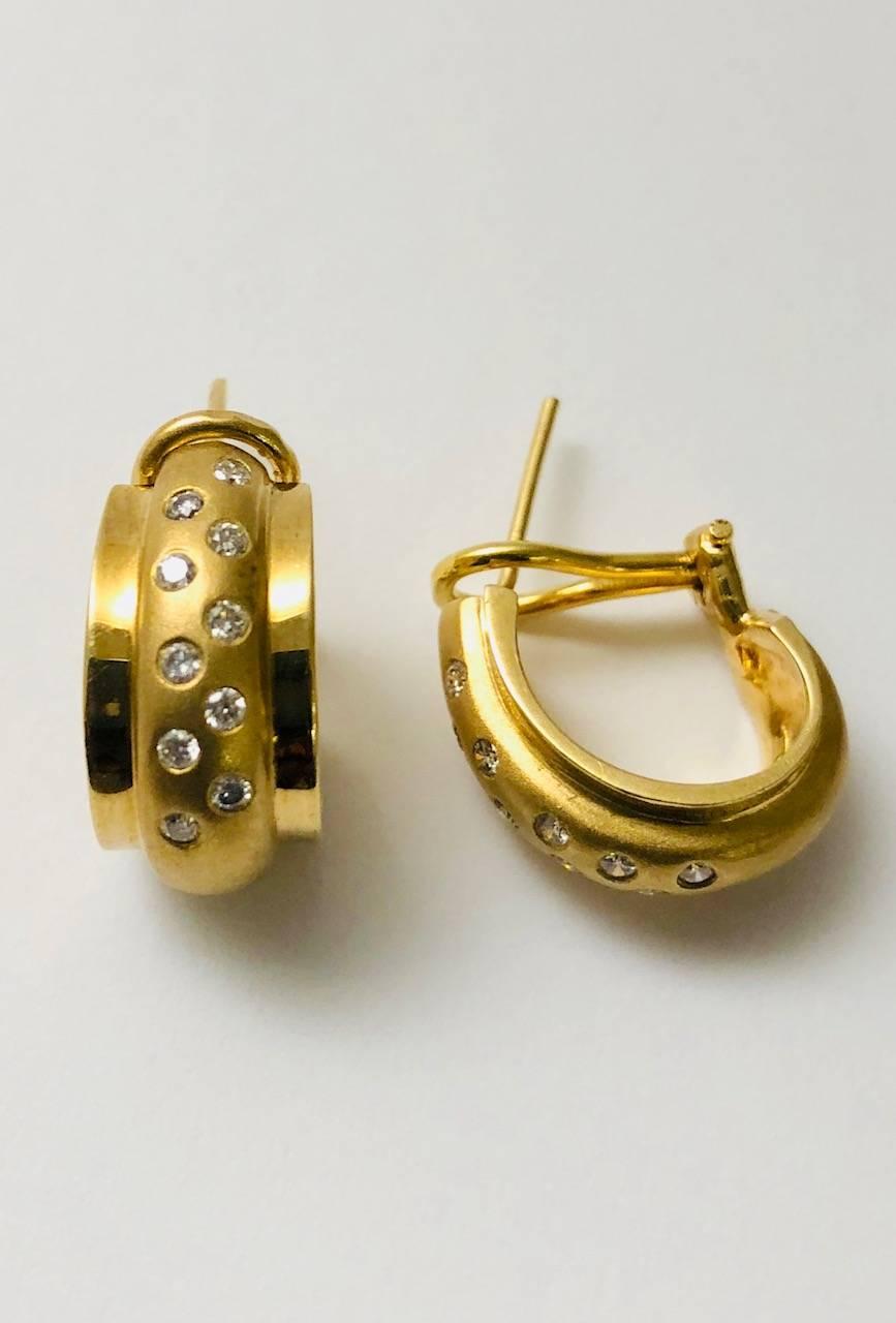 You just found an earring for day into night wear!  Crafted in 14 karat yellow gold, these pierced half hoop earrings have a striking design.  Highly polished sides embrace a matte finish raised center section sprinkled with burnished diamonds