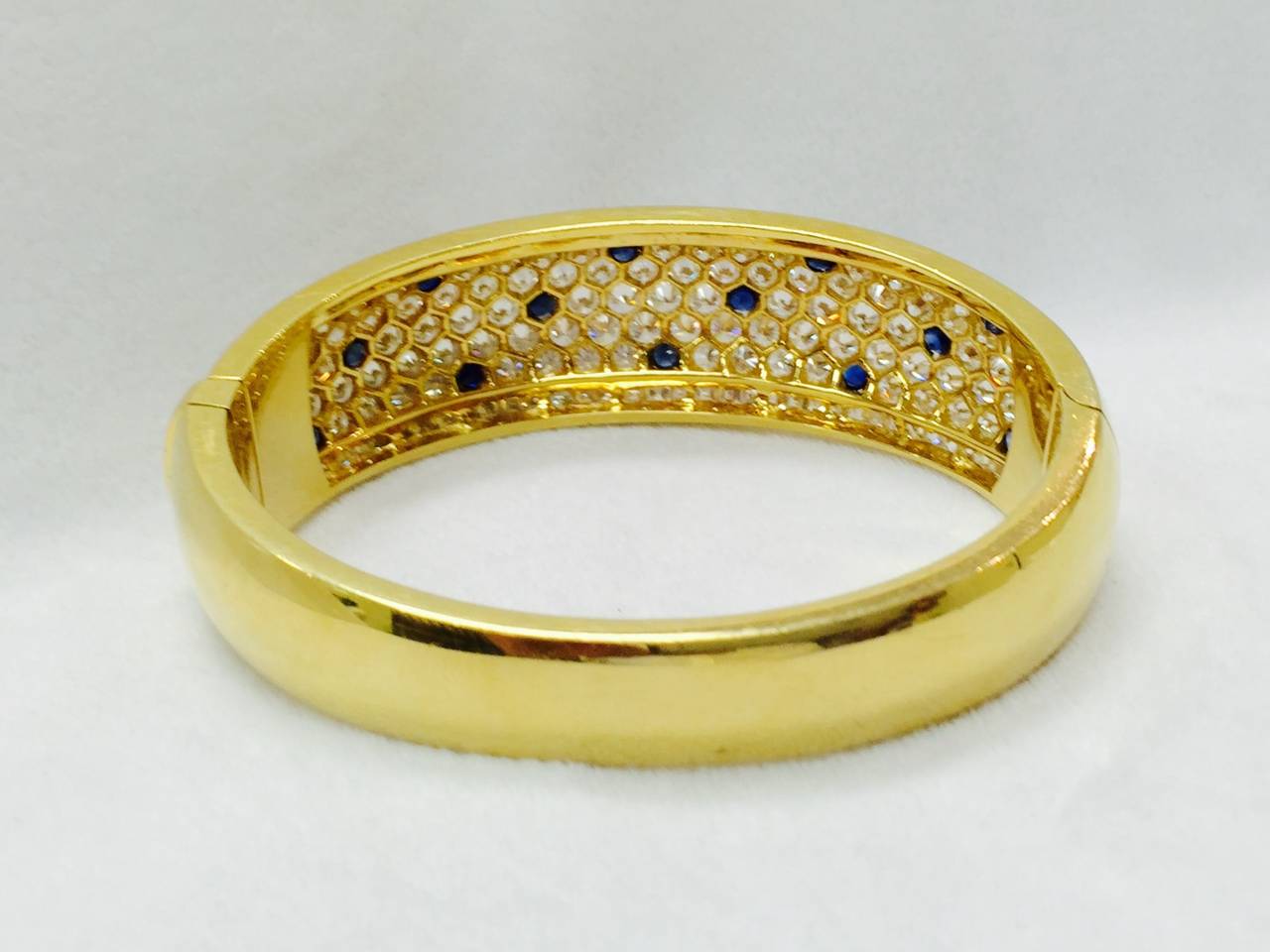 Pictures cannot do justice to this 18K Yellow Gold tapered bangle bracelet.  Individually prong set brilliant cut diamonds are colorless F grade.  Clarity an impressive VVS grade.  Adding to the play of light are channel set Princess cut diamonds on