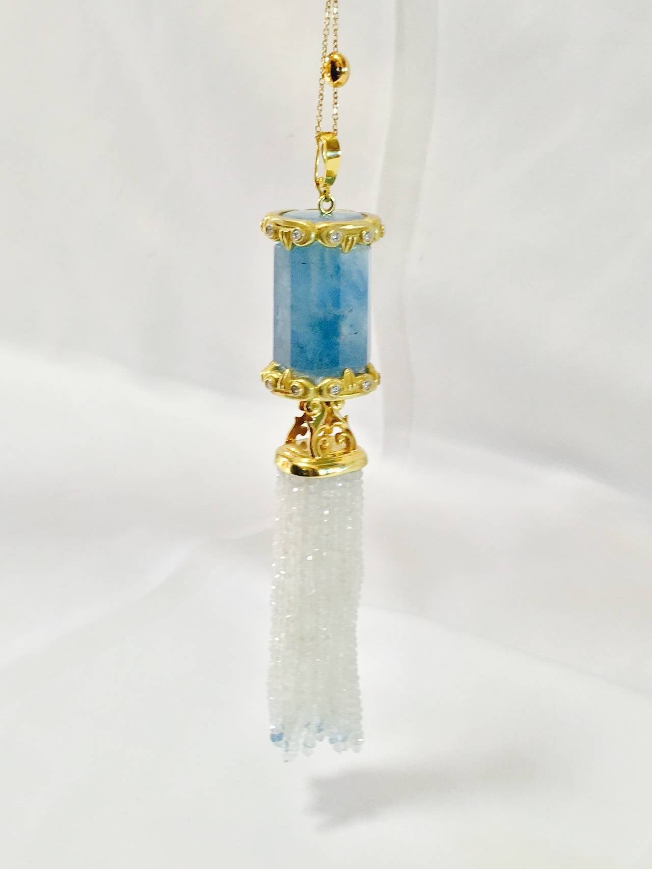 An incredible, one of a kind, enhancer on an 18K Yellow Gold Bead station necklace.  Artfully designed using a fabulous barrel cut Aquamarine displayed by custom made top and bottom 