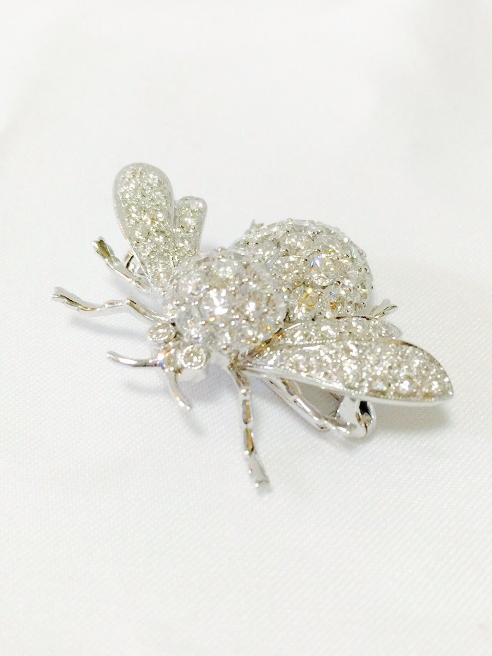 Buzz will be created whenever you don these fabulous bee pins!  Crafted in 18K White Gold, these are substantial and intriguing bees!  The all diamond bee boasts brilliant cut diamonds having E color, VS1 clarity and a total weight of approximately