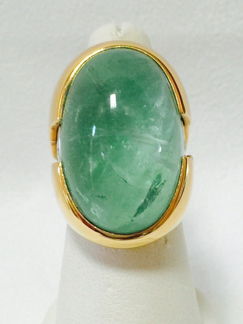 A breathtaking oval cabochon Emerald nestled in a 3/4 bezel setting.  Light emerald green displays a beautiful jardin within. Emerald has an approximate weight of 45 carats +.  High style created by 18K white gold inserts in a lightening bolt