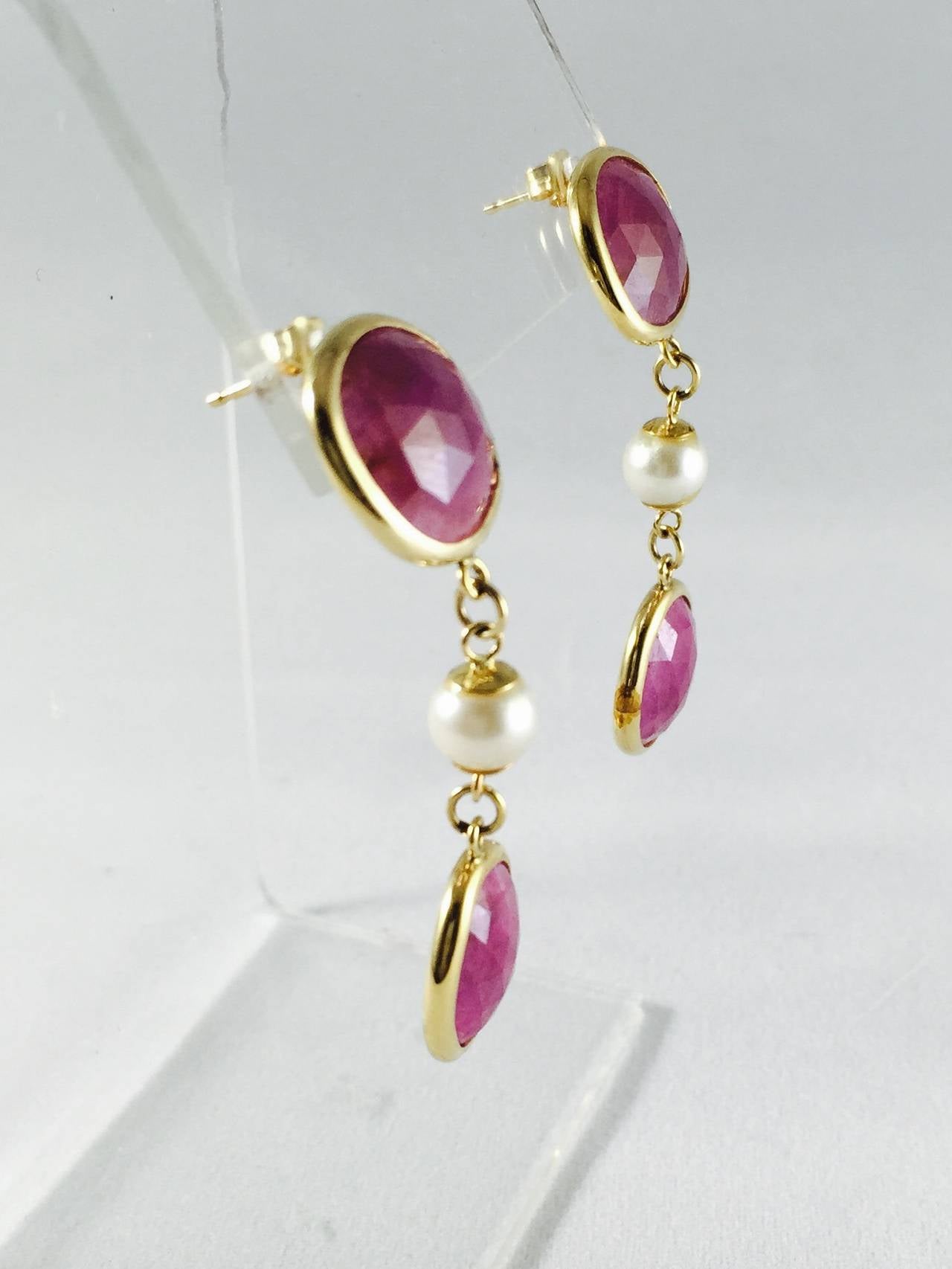 Beautifully made drop earring fabricated from 14 karat yellow gold featuring bezel set checkerboard faceted rubies.  Between each ruby sits perfectly matched lustrous cultured pearls.  These earrings dance with your every move making them incredibly