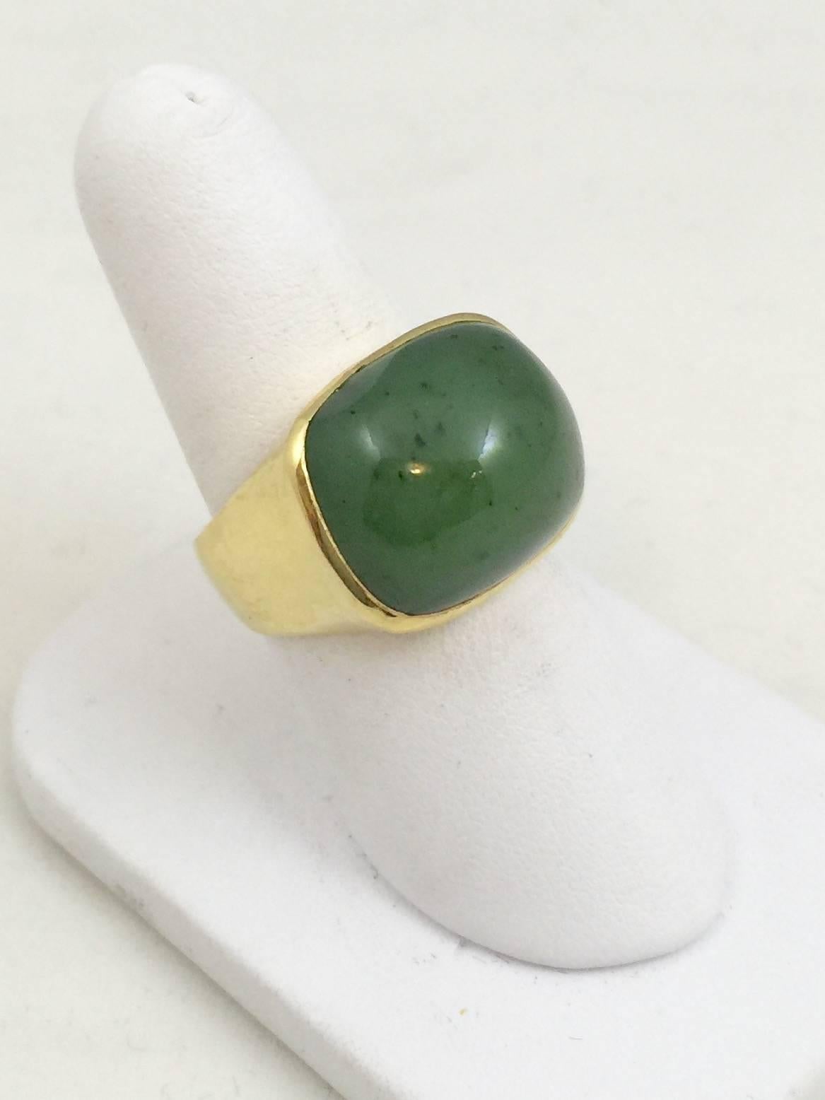 This 18 karat yellow gold ring can be worn by a man or a lady.  Clean, classic setting boasts a magnificent piece of green jade.  Setting has a hammered finish.  Shown in size 9 but can be sized up or down as needed.  Simply stated: a classic ring