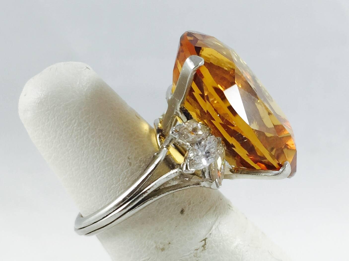 Beautifully crafted in 18 karat white gold, this oval citrine will soon become your favorite!  The citrine has been heat enhanced, common in colored stones, and weighs an impressive 23.60 carats.  Three marquise shape diamonds grace each side adding
