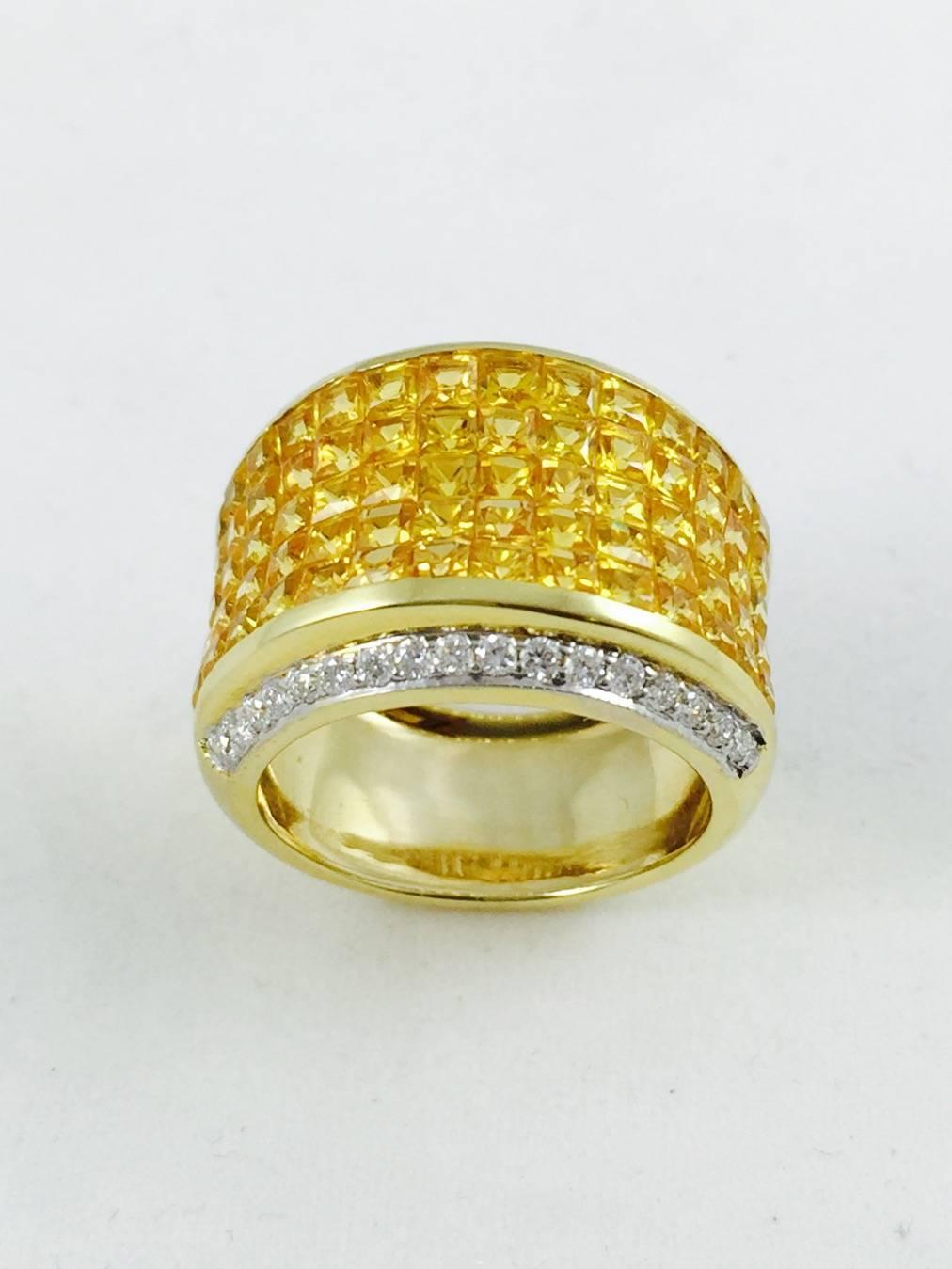 Impeccably crafted in Europe, this stunning 18K yellow gold tapered band style ring has row upon row of invisibly set, perfectly matched, princess cut yellow sapphires.  Bordered top and bottom by a row of channel set brilliant cut diamonds.  Size 7