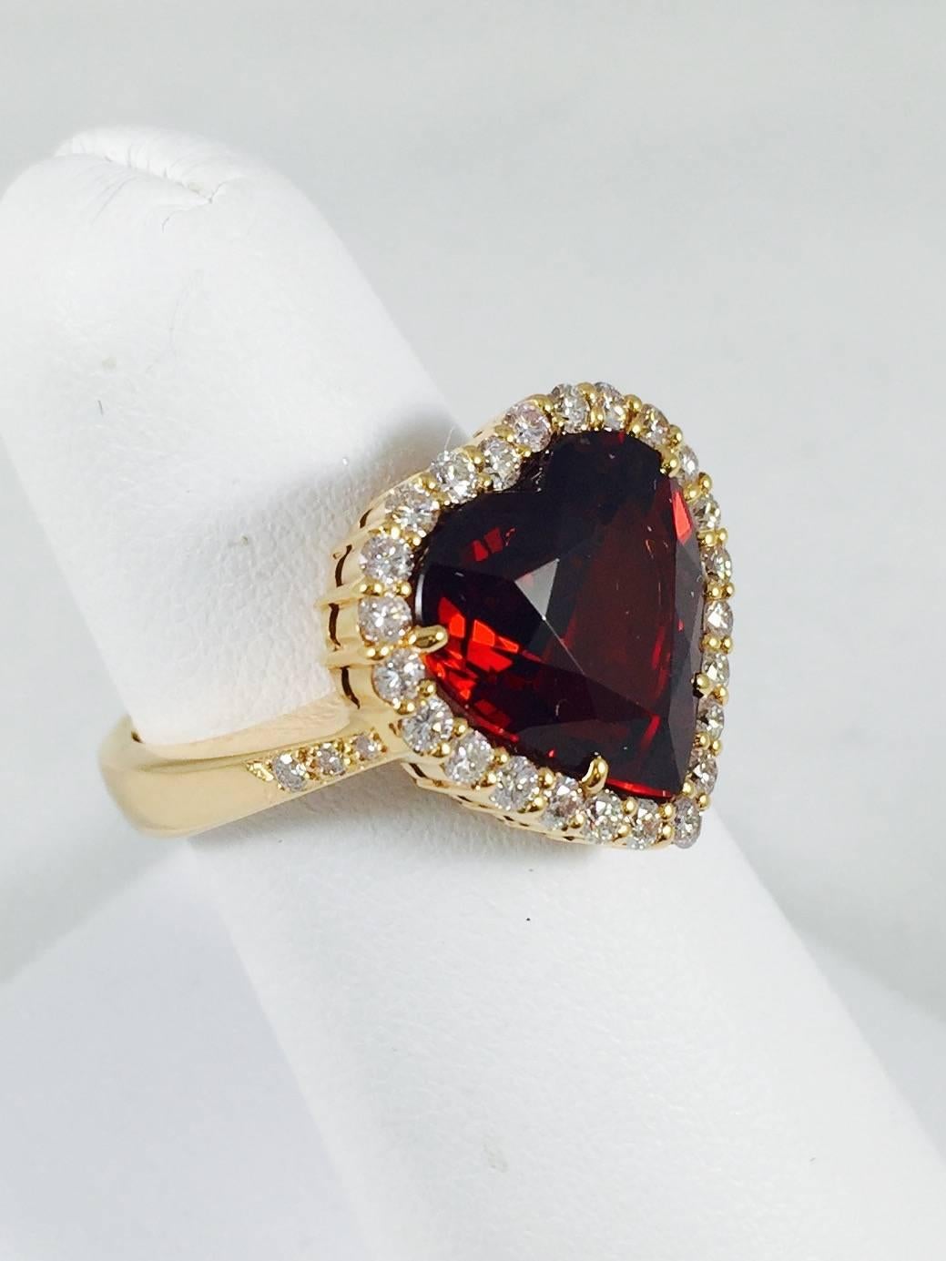 Definitely the most endearing shape in jewelry. Artfully crafted in 18 Karat Rose Gold enhancing the beauty of this rarely found Spessartite Garnet, 8.18 carat, heart shape stone.  For further beauty, the heart is framed in Very Light Pink brilliant