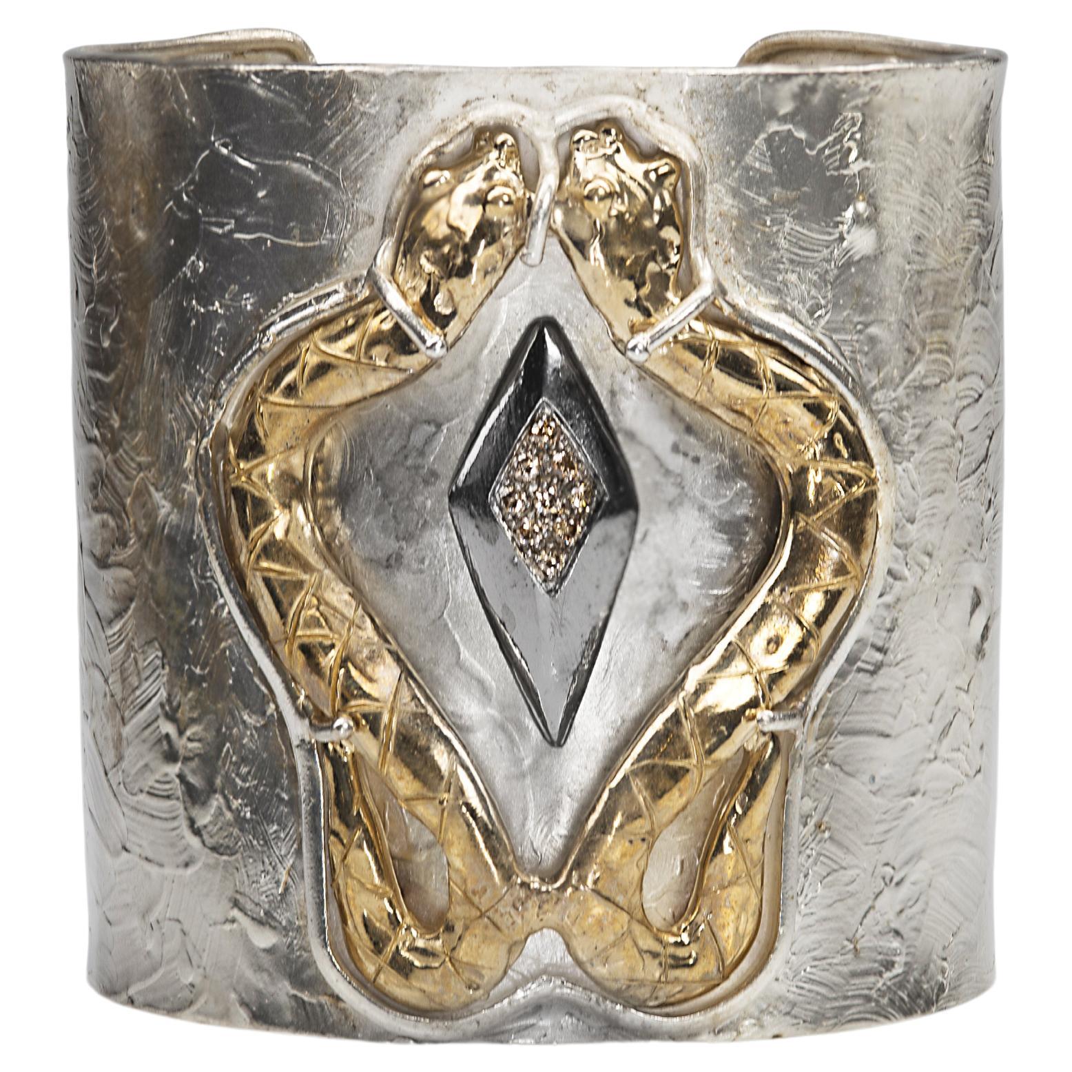 Rossella Ugolini Design Collection  a Fierce Sensual Cuff Snakes Bracelet Handcrafted in 24 Karat Gold Plated Silver Sterling and 0.20 Karat Brown Diamonds.
On the Modern Silver Sterling bracelet two 24 Karats gold plated bronzed snakes meet and by