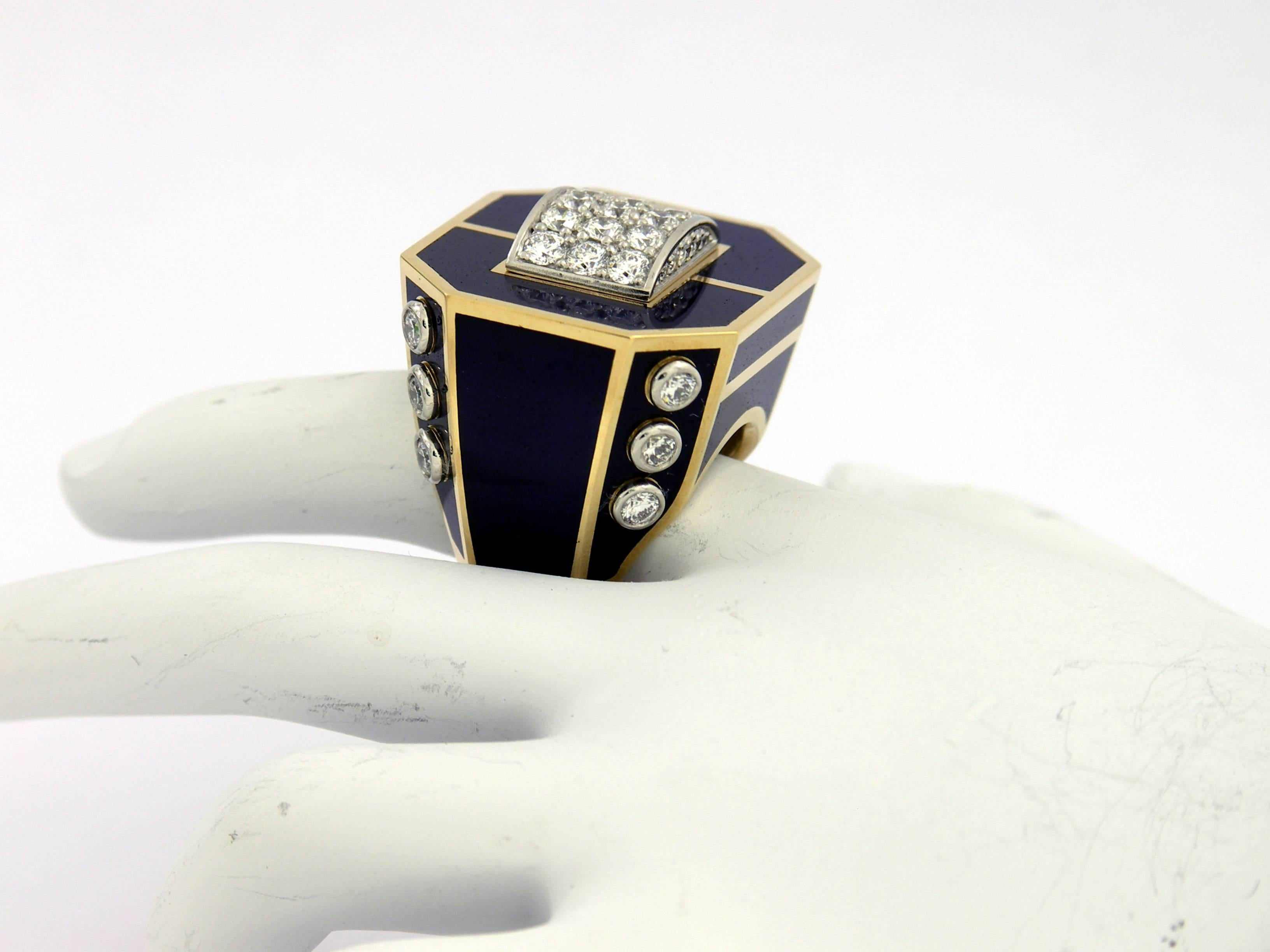 A grand ring in 18K yellow gold, and platinum, incorporating both pave' set as well as bezel set diamonds. With a design area of 1 inch long, and 1 1/8 inches wide, it features a geometric outline. Accenting the ring are 12 cells of cobalt blue