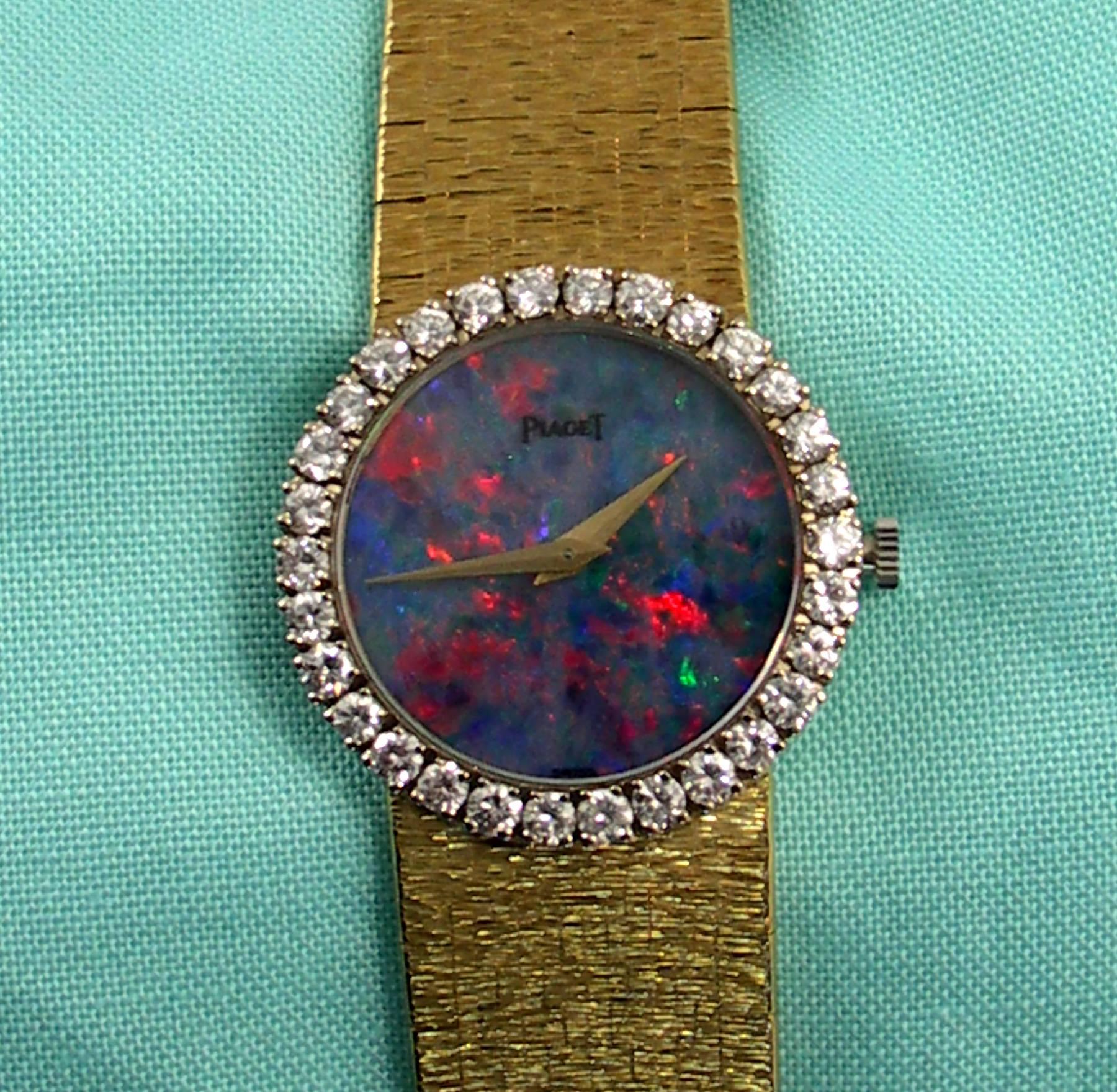 A ladies 18K yellow Gold Piaget wristwatch with diamond bezel, set with approximately 1ct of round brilliant cut diamonds. This fabulous watch also features a black opal dial measuring 22mm. Overall length is 6 1/4 inches.