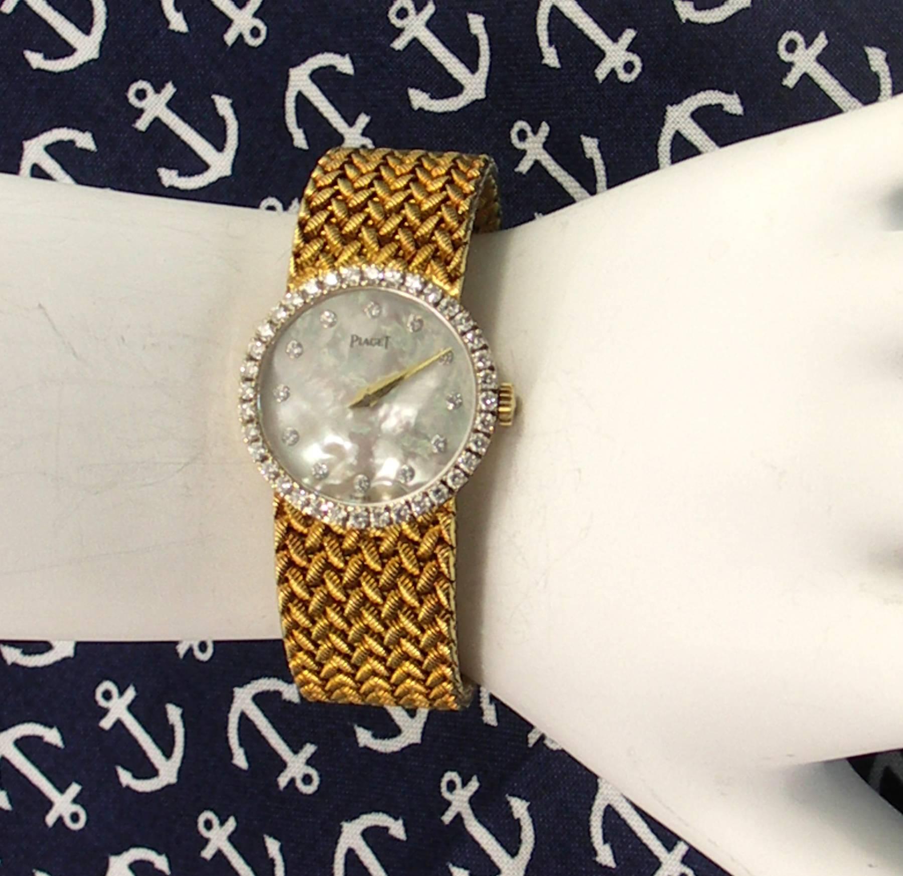 A lady's 18K yellow gold Piaget wrist watch with diamond bezel, and mother of pearl dial with diamond markers. In total, there are approximately 1.25ct of round brilliant cut diamonds.
Overall length is 6 1/8 inches.