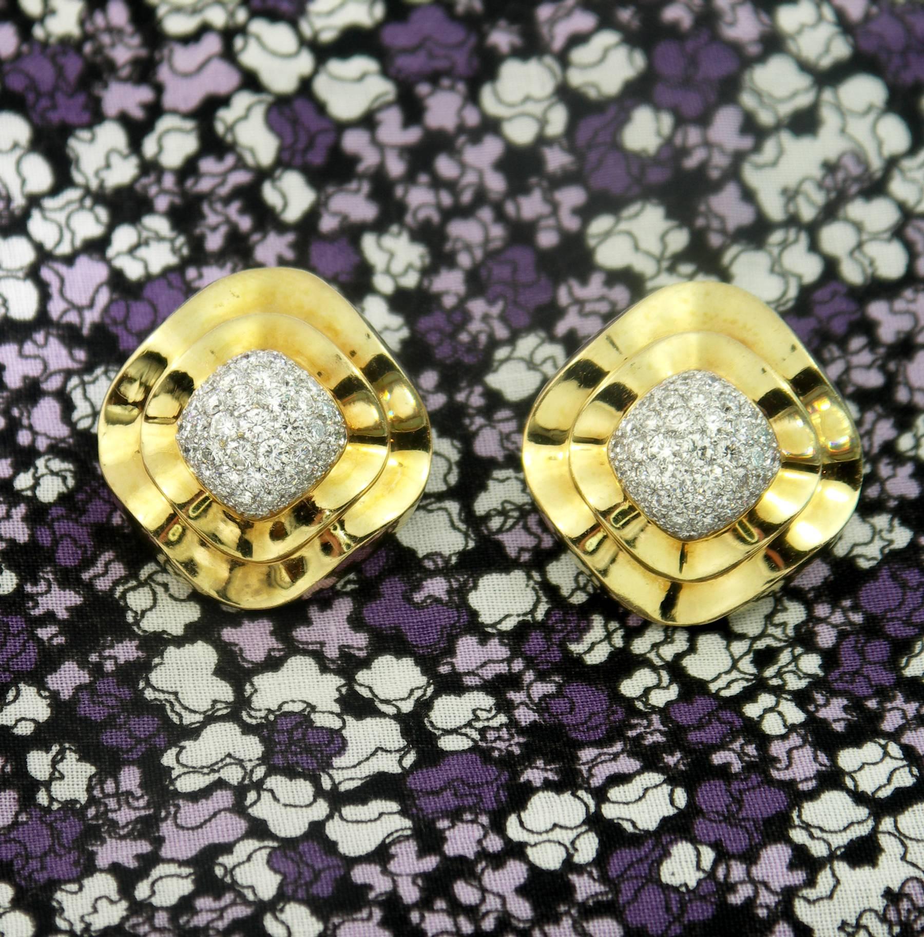 A pair of 18K yellow gold earrings, featuring a swooping design, with a total of approximately 4.5ct of round brilliant cut diamonds of overall F/G color, and VVS2/VS1 clarity. The pave set domes are constructed of 18K white gold, and the gallery is