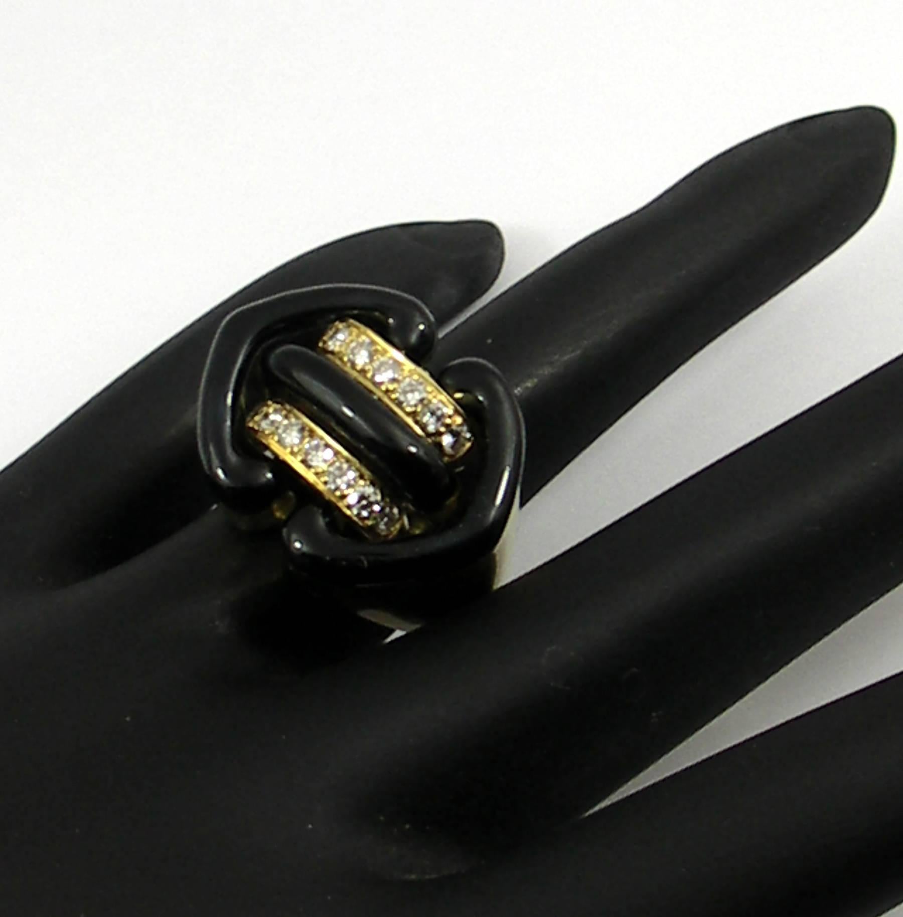 An 18K gold ring signed Clunn for Andrew Clunn, with a tailored design. Measuring 3/4 of an inch long, and 1 inch wide, the design is beautifully embellished with black enamel, and set with 14 round brilliant cut diamonds, weighing 0.66ct total