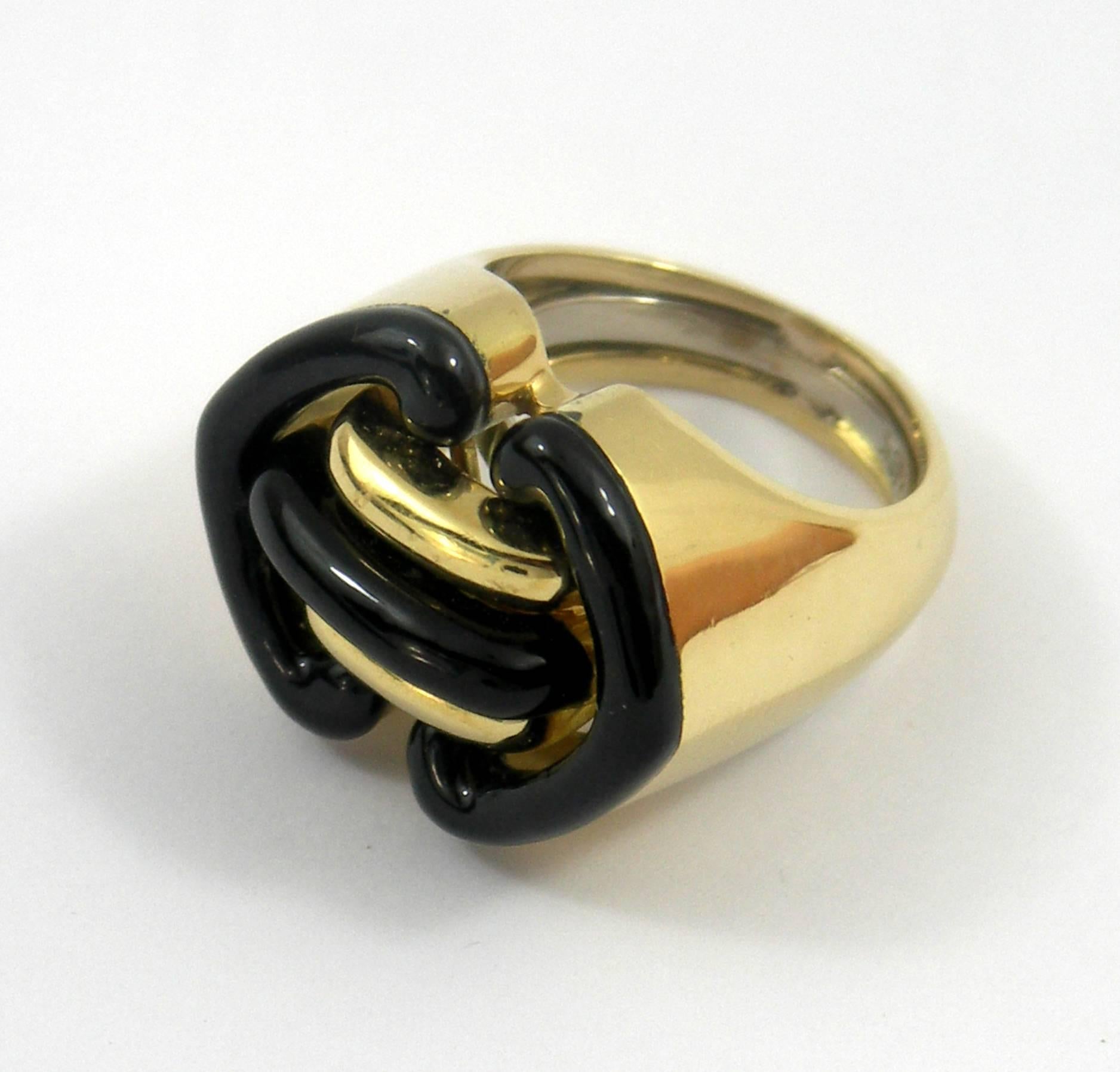 A geometric design 18K yellow gold ring by Andrew Clunn. Measuring 7/8 of an inch wide, and 5/8 of an inch long, it has a tailored look, accented by black enamel. Size 5 1/2.