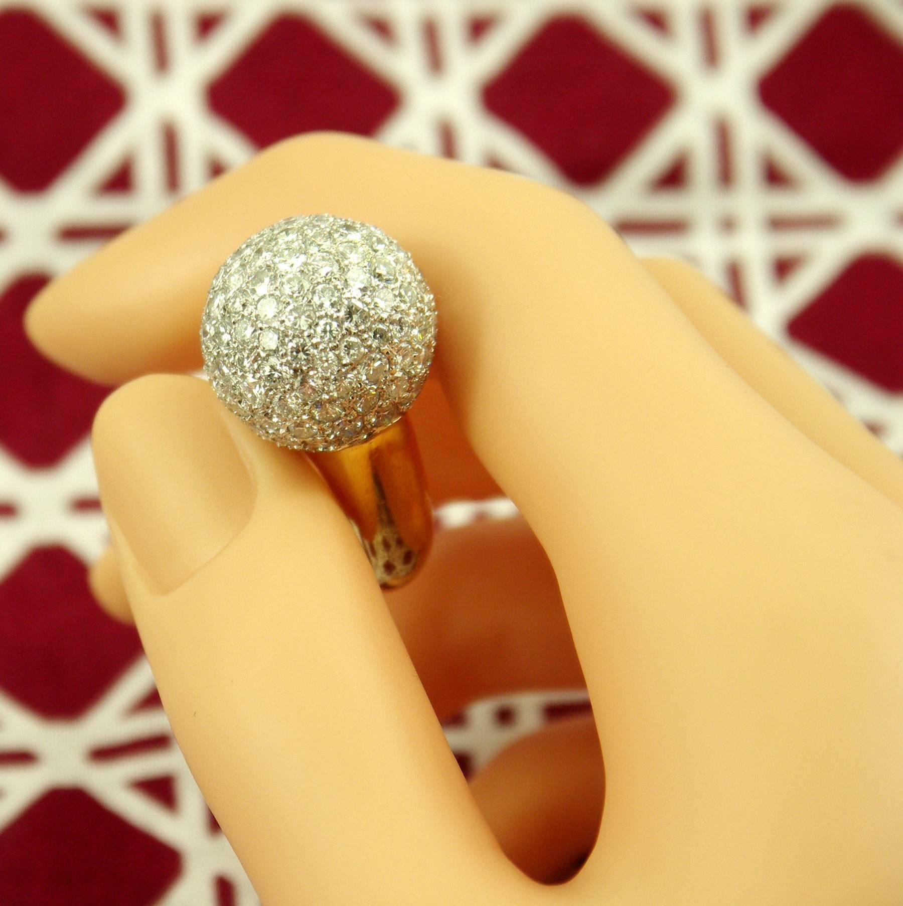 An 18kt ring centering on one diamond pave' ball measuring 18mm, totaling 124 round brilliant cut diamonds, approximately 8.50cts. Size 6 1/2