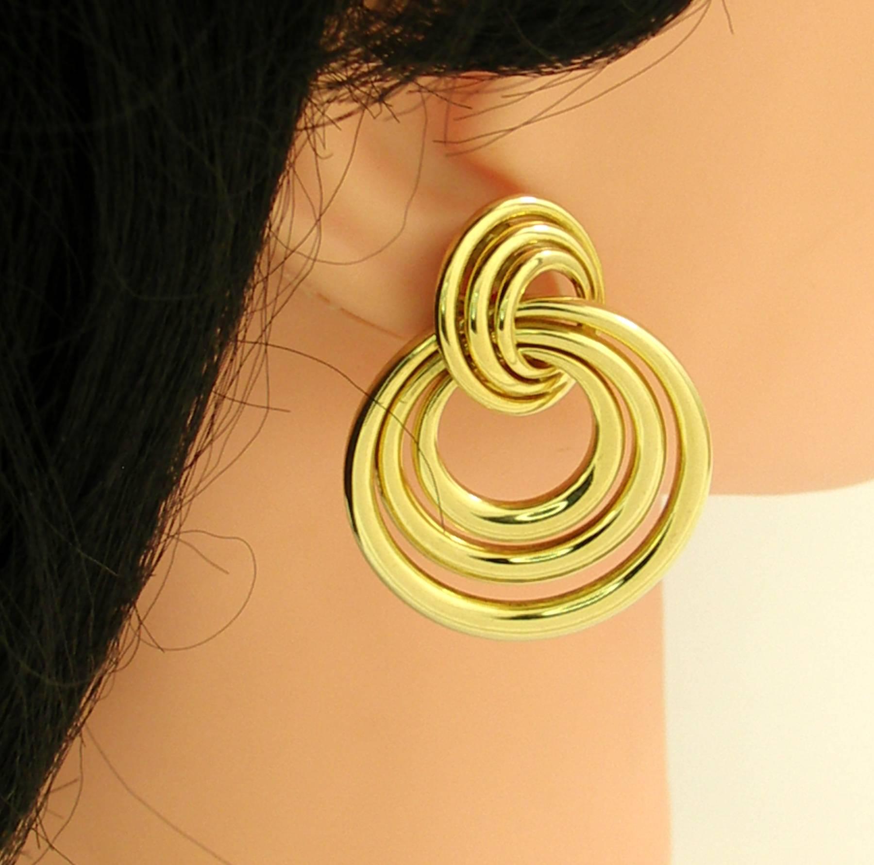 A pair of 18Kt yellow gold earrings measuring 1 9/16 long and 1 5/16 inches wide, with an artistic spiraled design. Signed Cartier