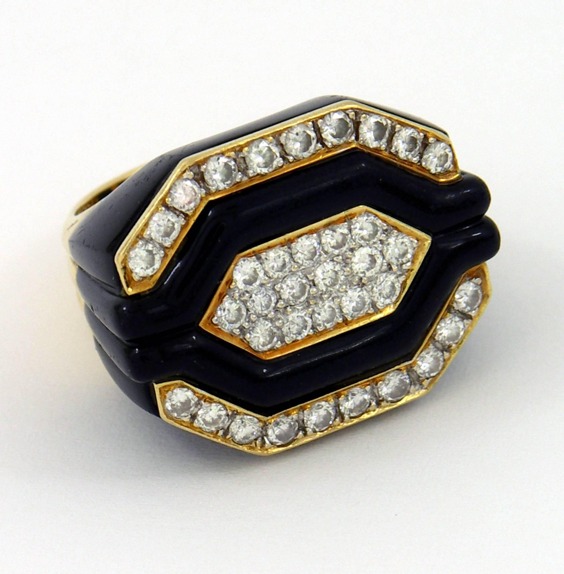 An 18K yellow gold ring centered on a hexagonal section of pave set diamonds, accented with onyx strips bordered by additional pave set diamonds for a total approximate weight of 1.75ct. The shoulders of the ring feature fluting in the onyx, which