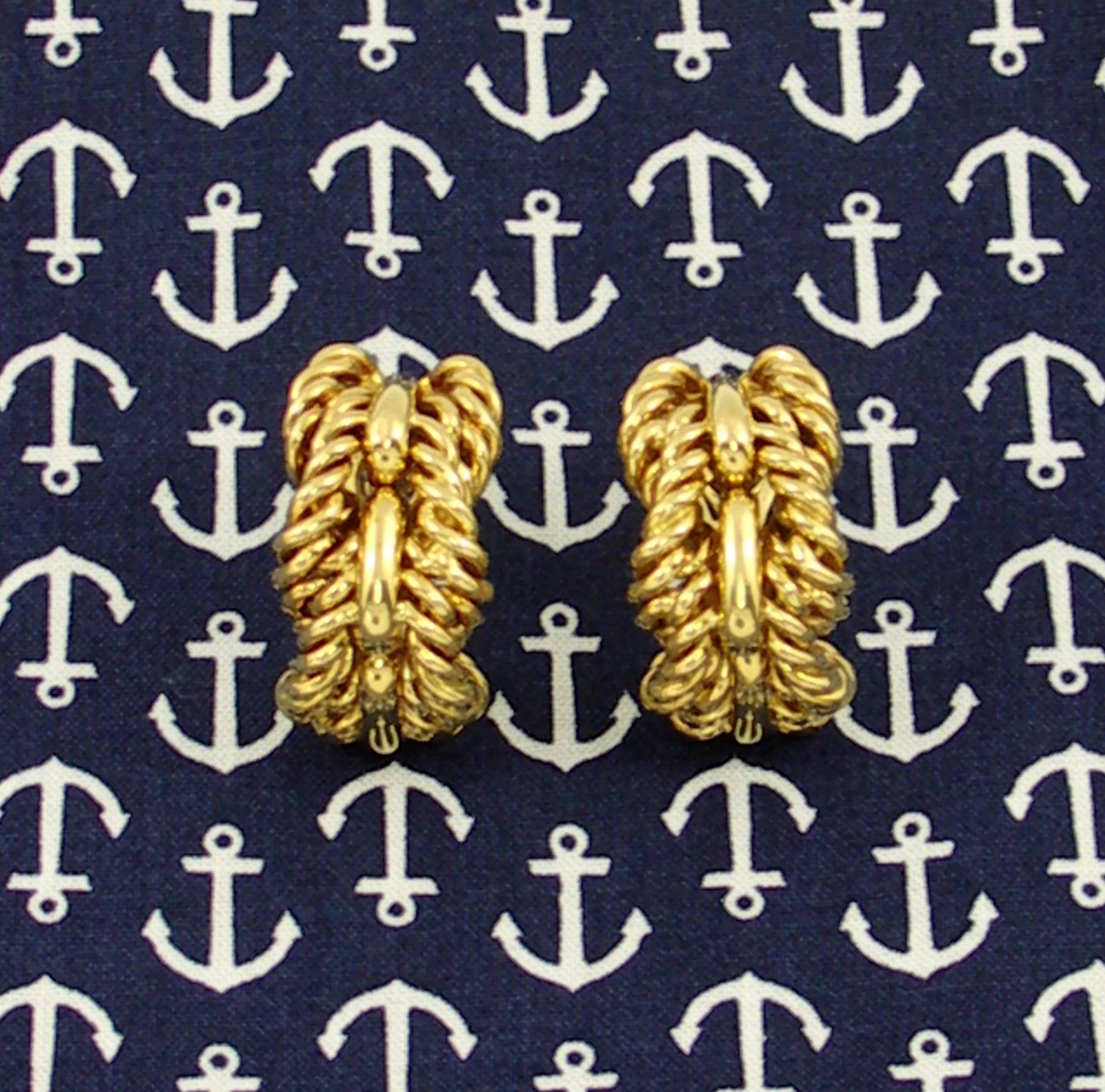 A pair of 18K yellow gold earrings measuring 5/8 of an inch wide, and 1 1/4 inches long, centered on high polished ingots atop a braided design. Signed Tiffany & Co.