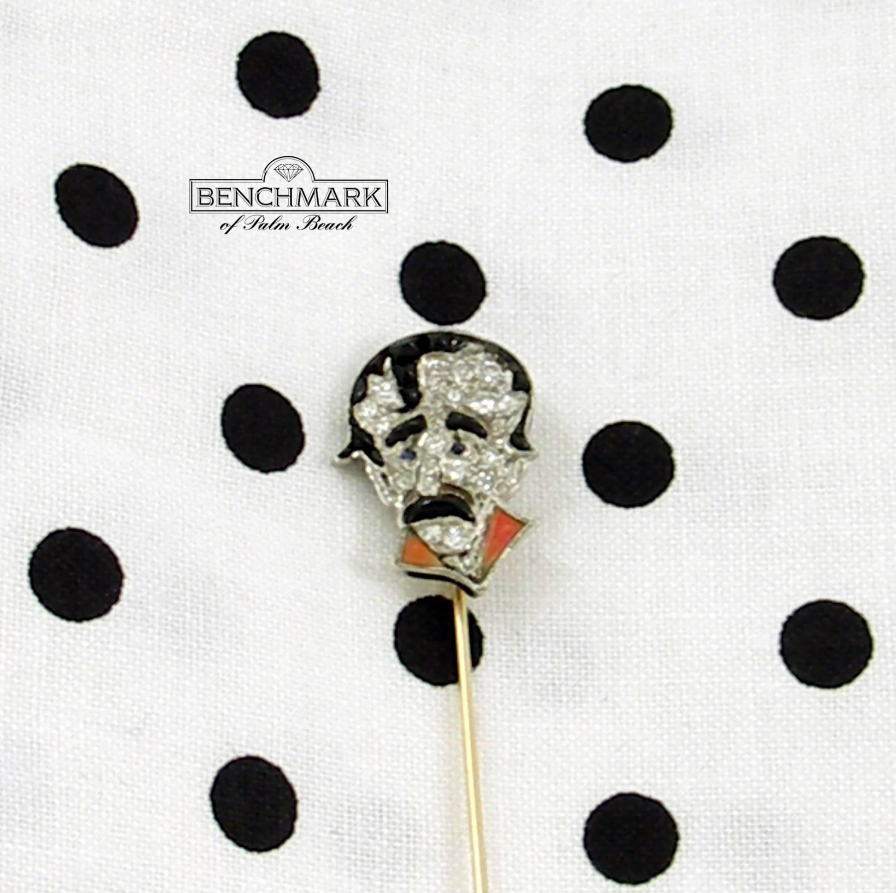 A rare and unique stickpin featuring a face comprised of diamonds, onyx hair, sapphire eyes, and coral lapels. This 