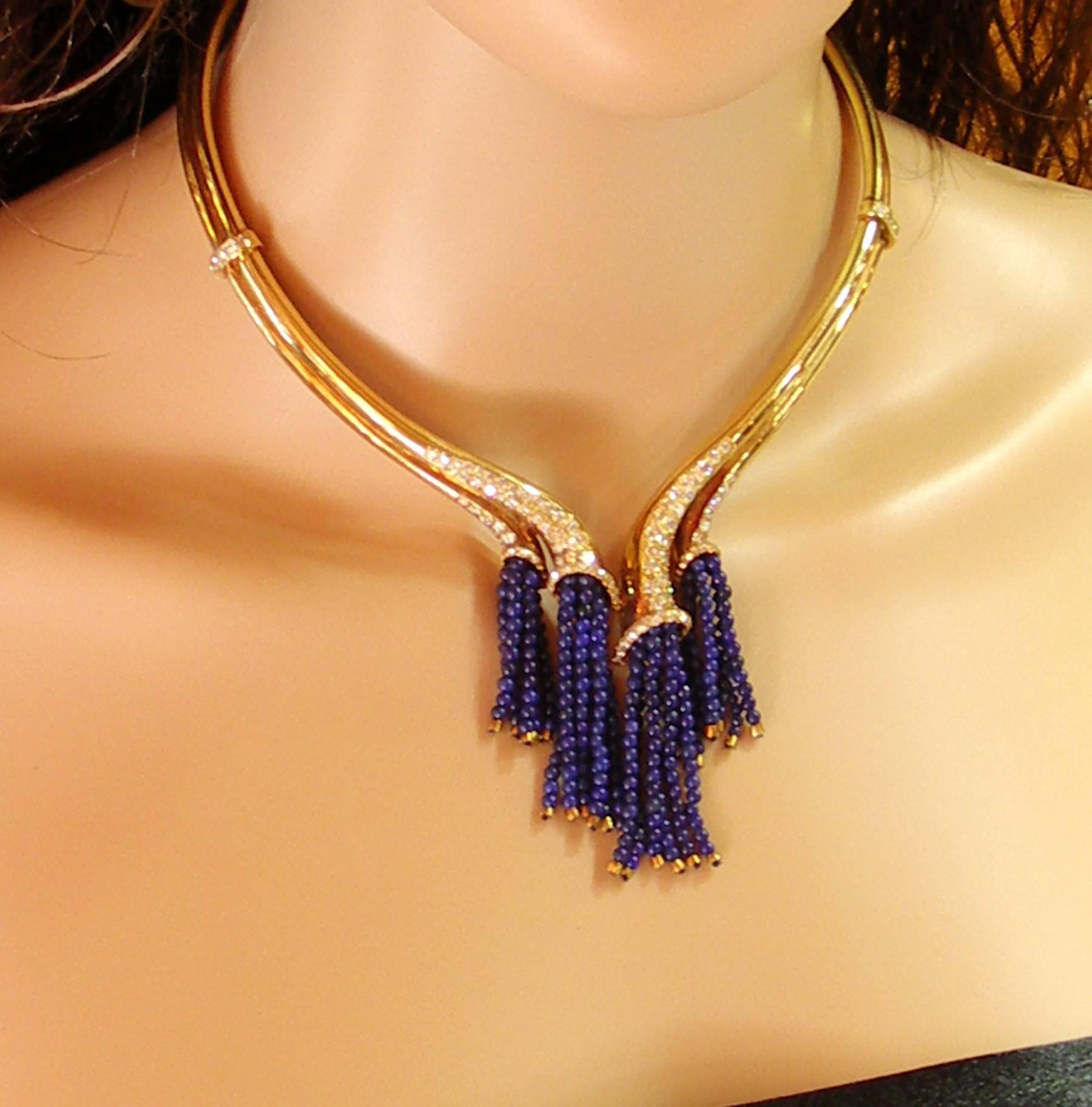 An 18K yellow gold collar necklace, comprised of two tubes flowing into four strands of lapis lazuli beads. This sleek necklace features  two stations, each set with five round brilliant cut diamonds. The ends are also pave set including the mouths