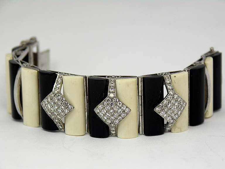 This hand made, 18K White Gold bracelet is made up of 7 individual links of onyx and bone strips. In the center are three diamond stations containing
approximately 5.75CT of modern brilliant cuts. Each link measures 1 1/16