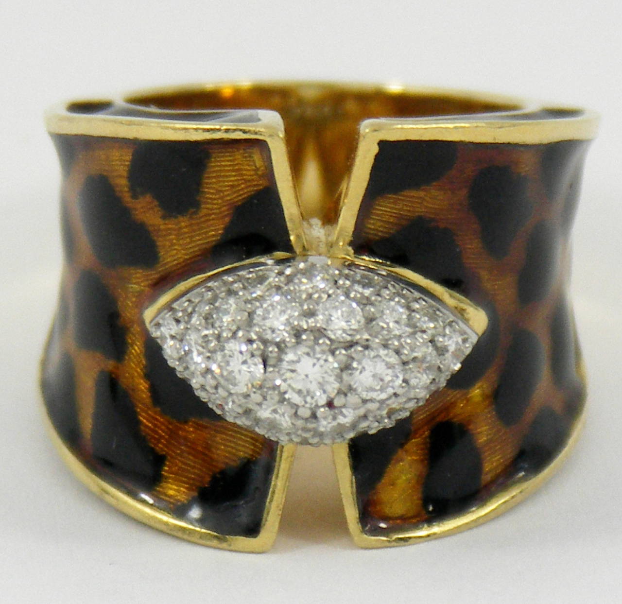 Made of 18K gold, this striking ring is beautifully enameled in a warm golden brown and black, leopard pattern. The center, diamond plate is set with 25
full cut diamonds weighing an approximate total of .90CT of overall F Color and VS1 Clarity.