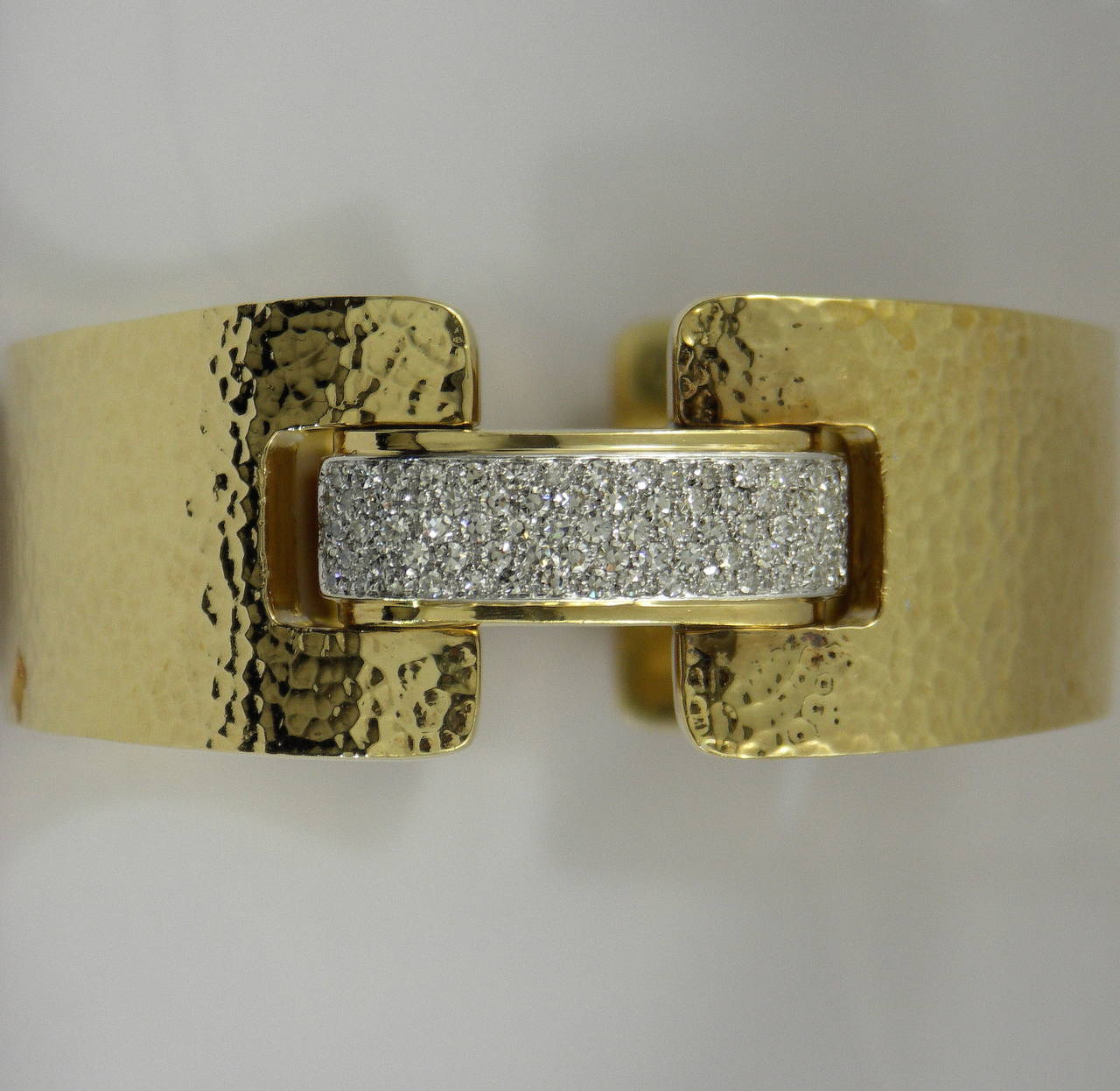An 18K yellow gold, hammer finished bracelet set with 80 single cut diamonds, weighing 2.25 ct total approximate weight. Diamonds are F/G color and VVS2/VS1 clarity. This sleek bracelet measures 1 1/8 inches wide, and 6 3/4 inches in circumference.