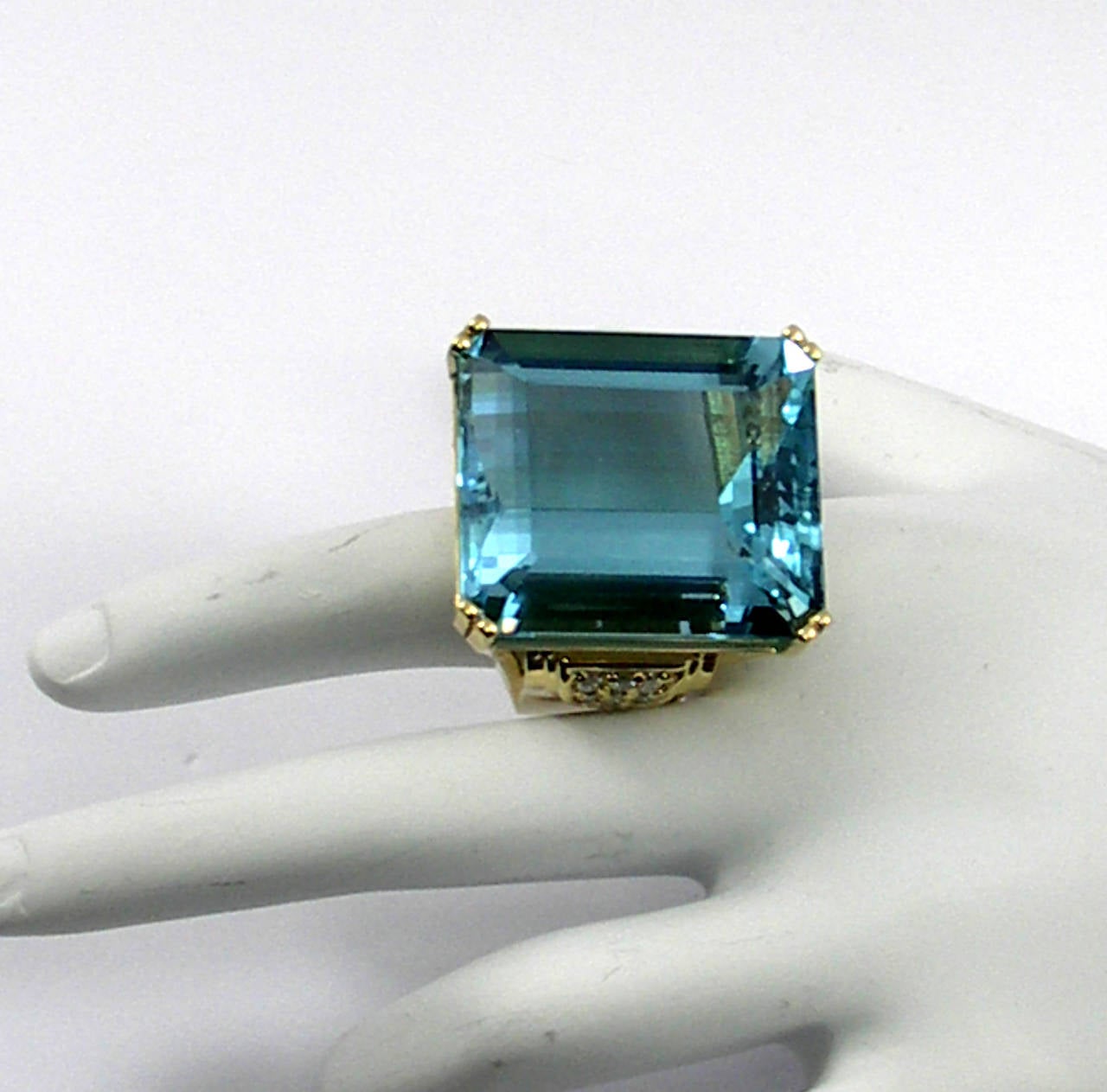 An amazing aquamarine weighing 62.88ct, set in a signature style ring. This ring features 18K yellow gold construction, and stylish design. The front and back of the ring are each set with 15 round brilliant cut diamonds, while each shoulder is set