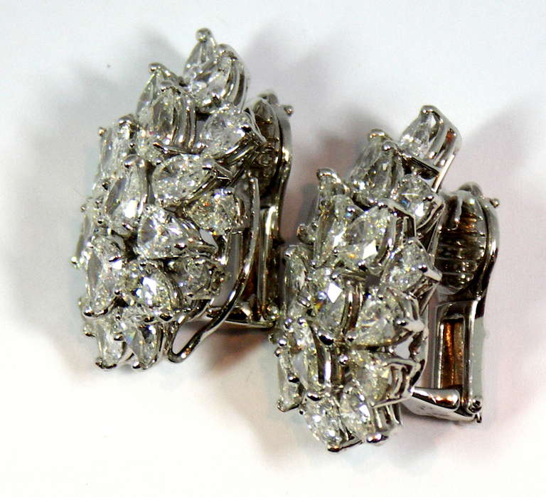 One pair of 18K white gold cocktail style diamond earrings. Each earring is set with 21 pear-shaped diamonds, for a total approximate weight of 15.5ct. Diamonds are of overall G/H color, and VS2 clarity. Each earring is 3/4 of an inch wide, and 1