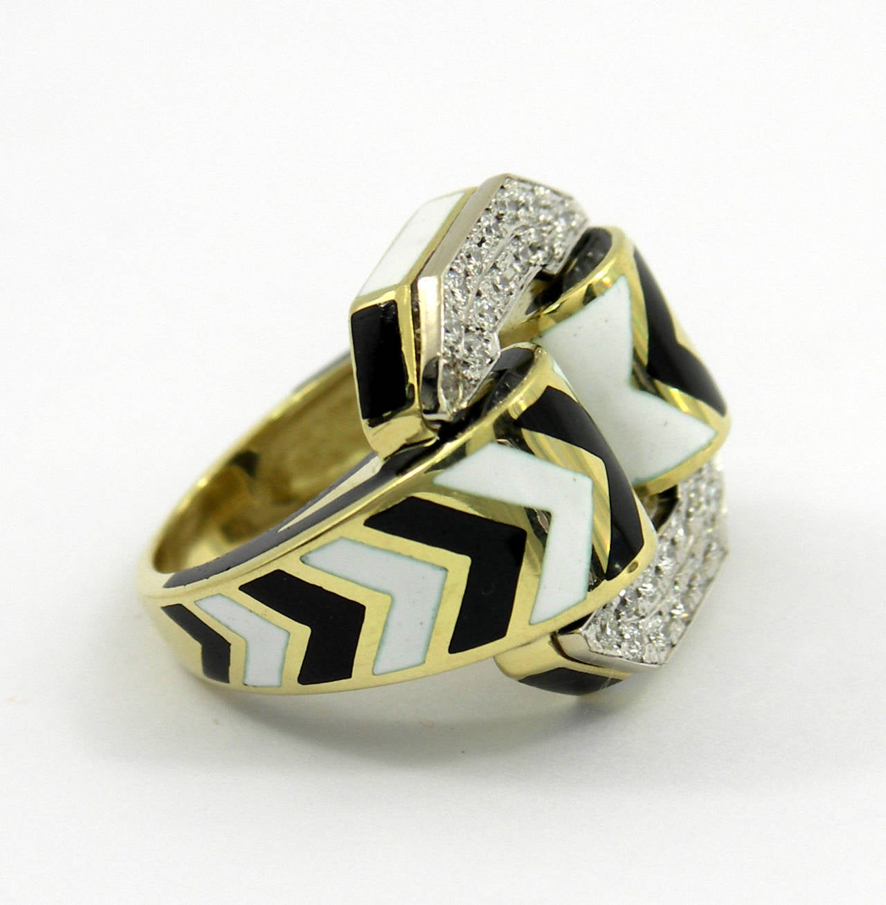 A captivating ring by David Webb crafted in 18K yellow gold, that has been beautifully enameled with alternating black and white chevrons. This stylish ring also has two platinum plates which have been set with assorted round brilliant cut diamonds